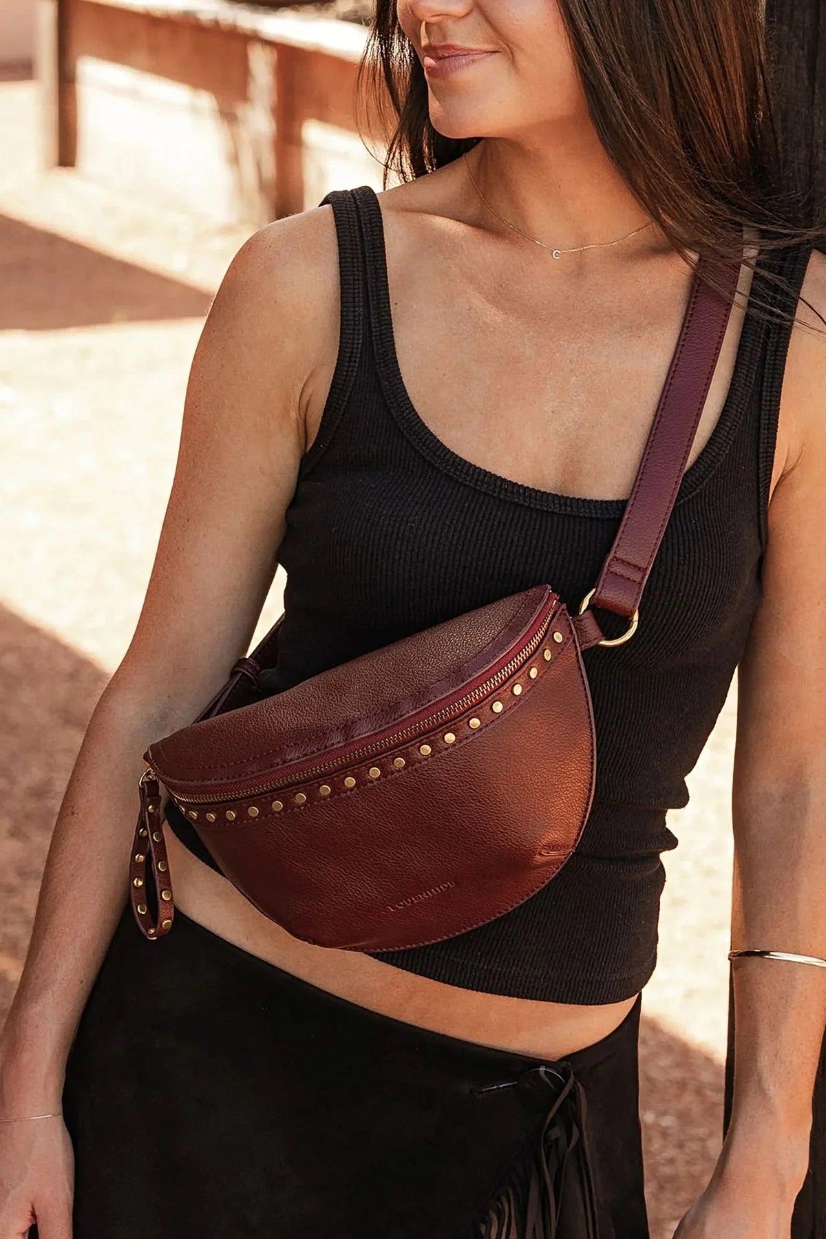 The Cassidy Burgundy Belt Bag worn across the chest with a black tank top.