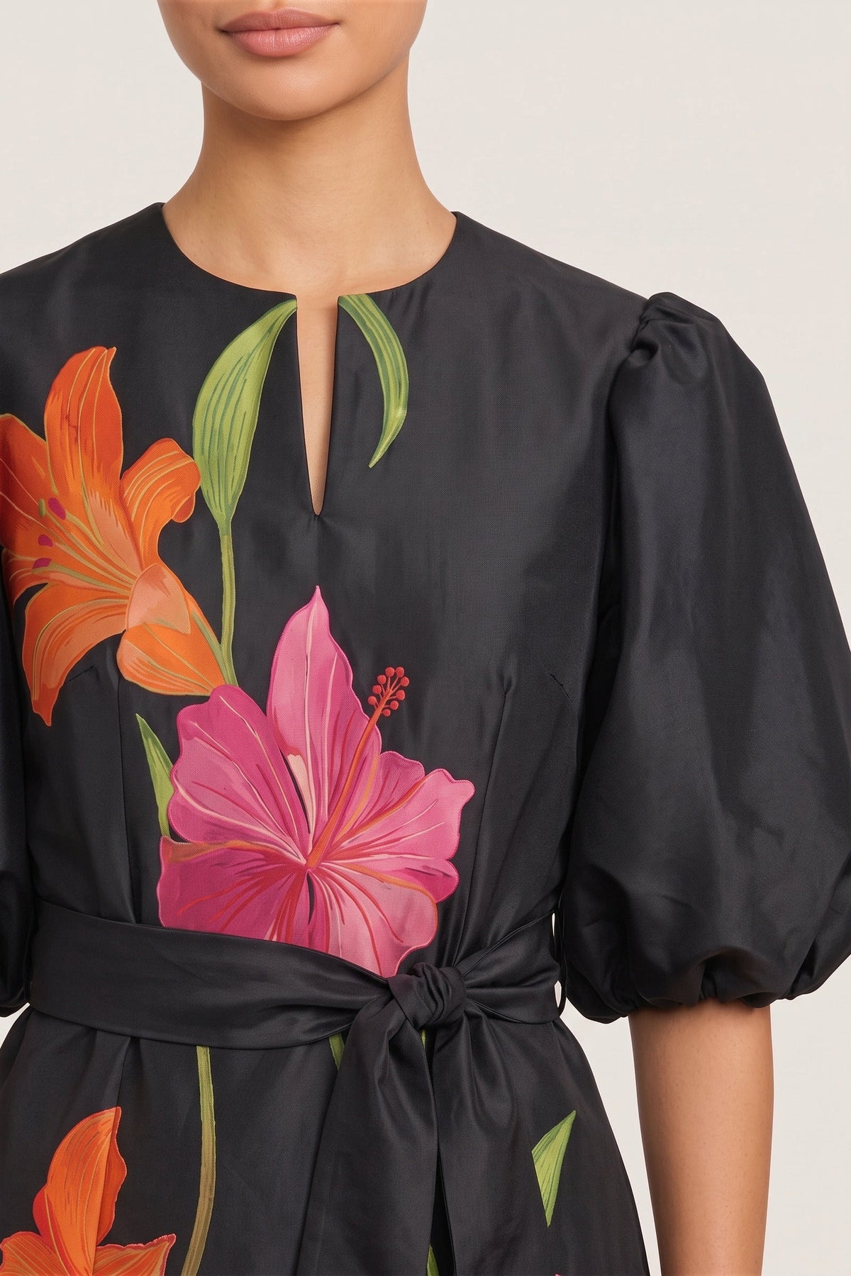 Close-up of the keyhole neckline, balloon sleeve, tie belt and printed lilies on the black taffeta.