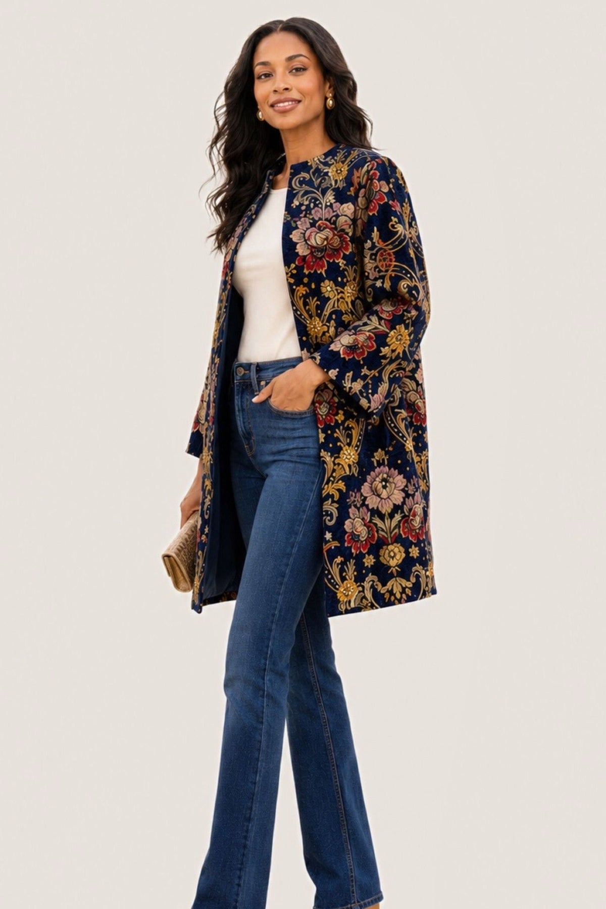 A woman modeling the Artisan Studded Corduroy Long Coat open over a white top and blue jeans against a plain studio backdrop