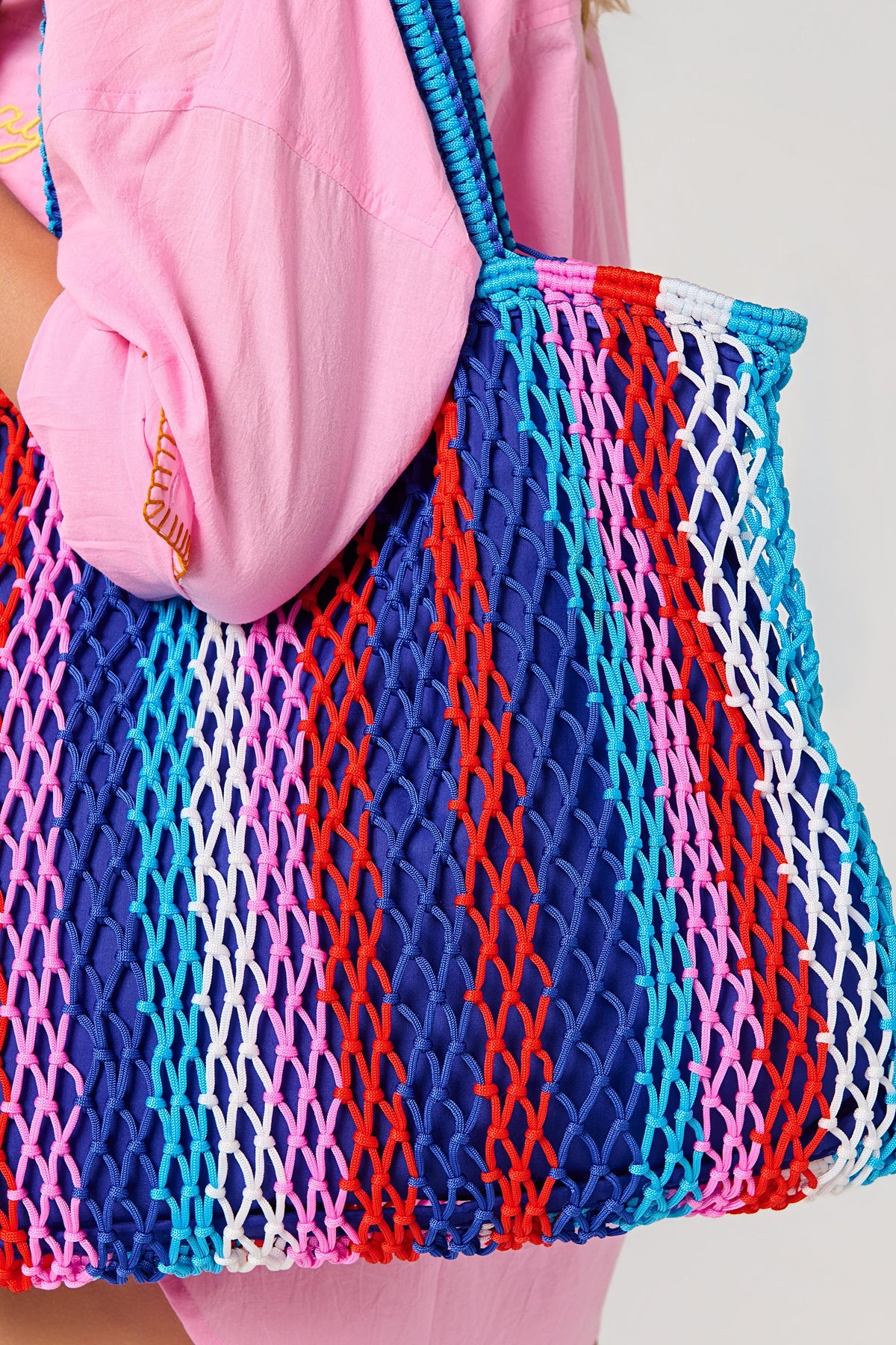 A close view of the Braziliana Stripe Tote on the shoulder, showing the open rope weave and stripes.