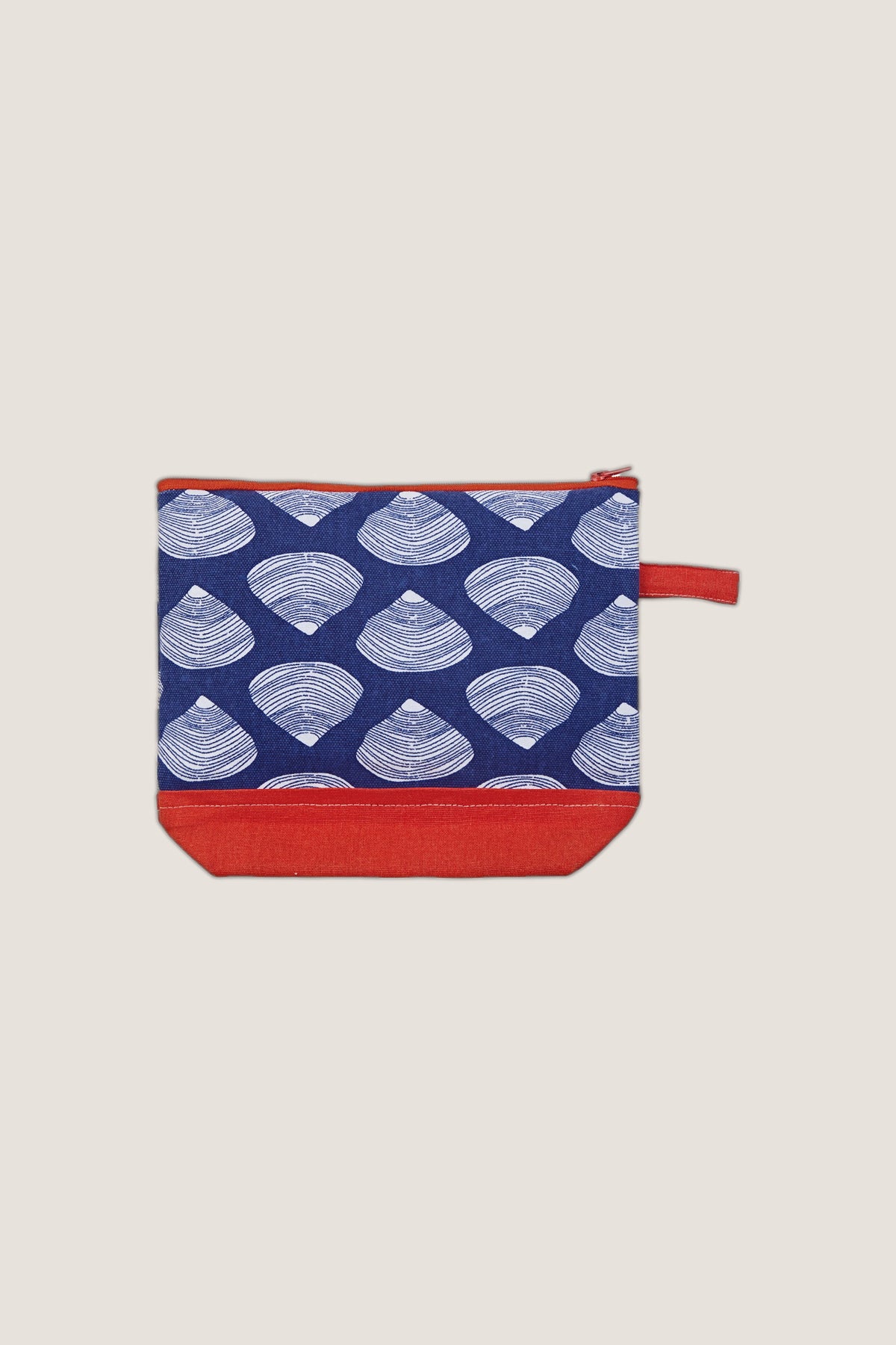 The Clamshell Cosmetic Bag in navy clamshell print with a coral base and pull tab, from the front.