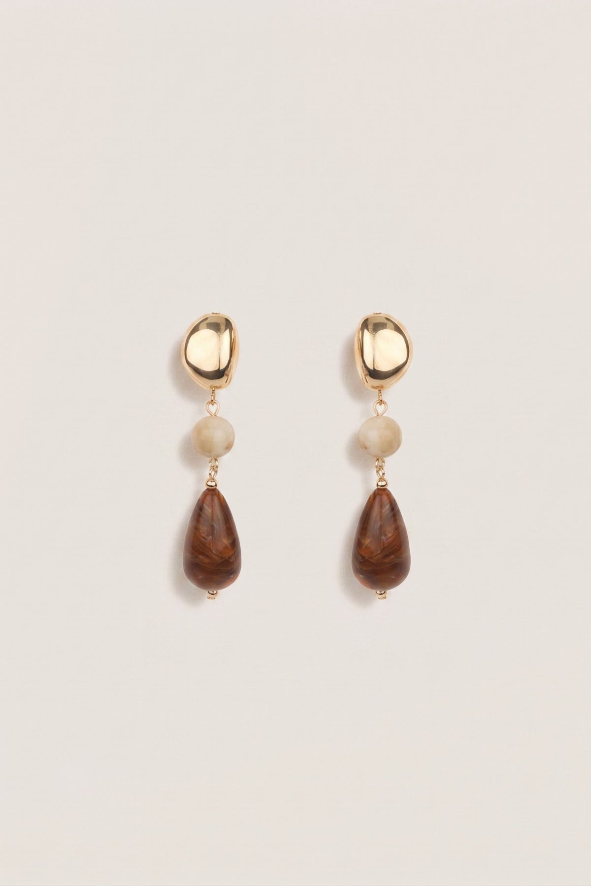 A pair of drop earrings with gold bean shape and then different colored gemstones