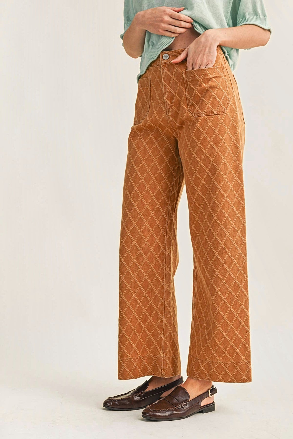Three-quarter view of the diamond quilted wide-leg pants with a hand in the front pocket.