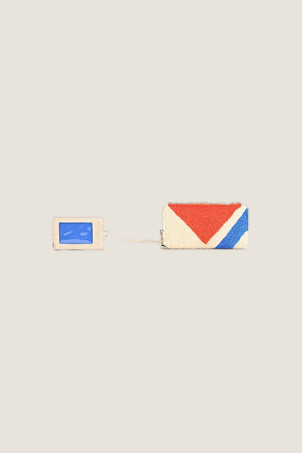 The back of the removable card holder with its clear blue ID window, clipped to the cream, red and blue chenille wallet.