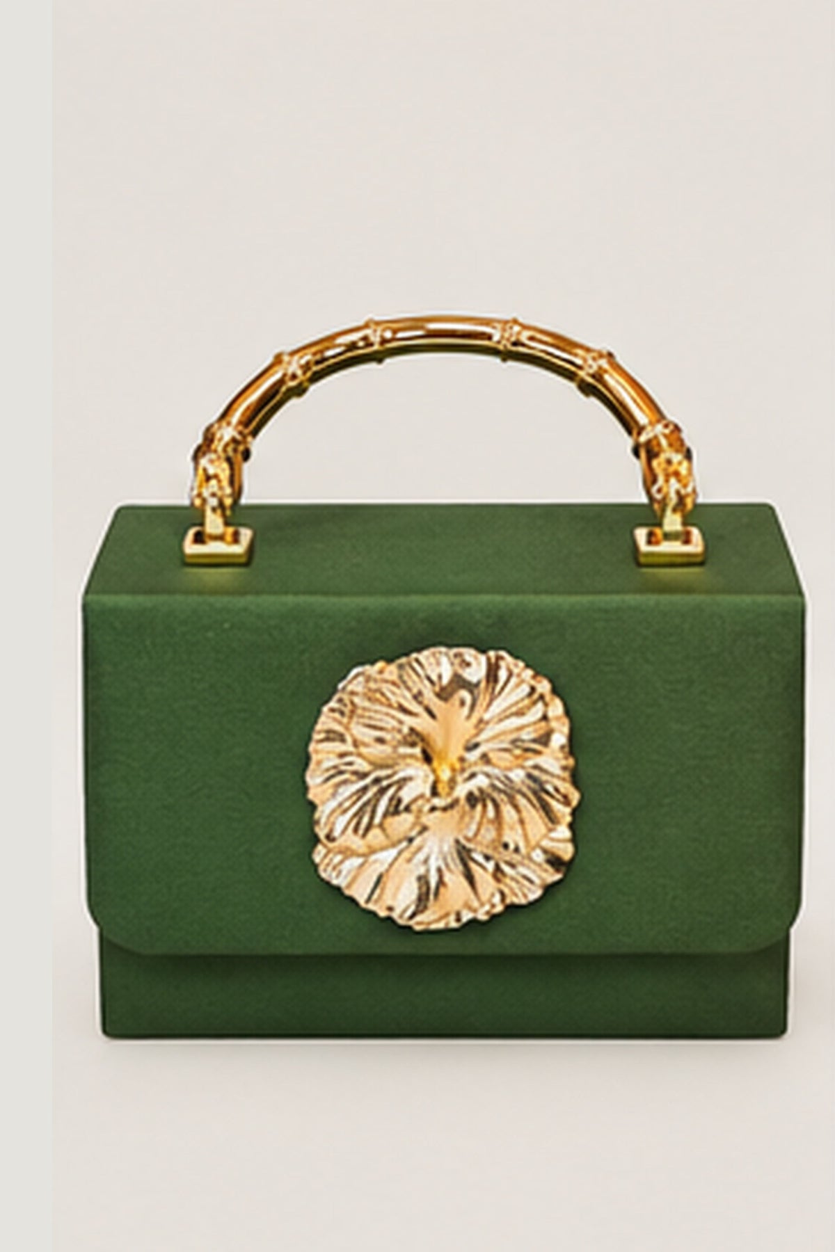 A structured green handbag with a gold bamboo-style top handle and a large gold floral clasp on the front, photographed against a plain light background.