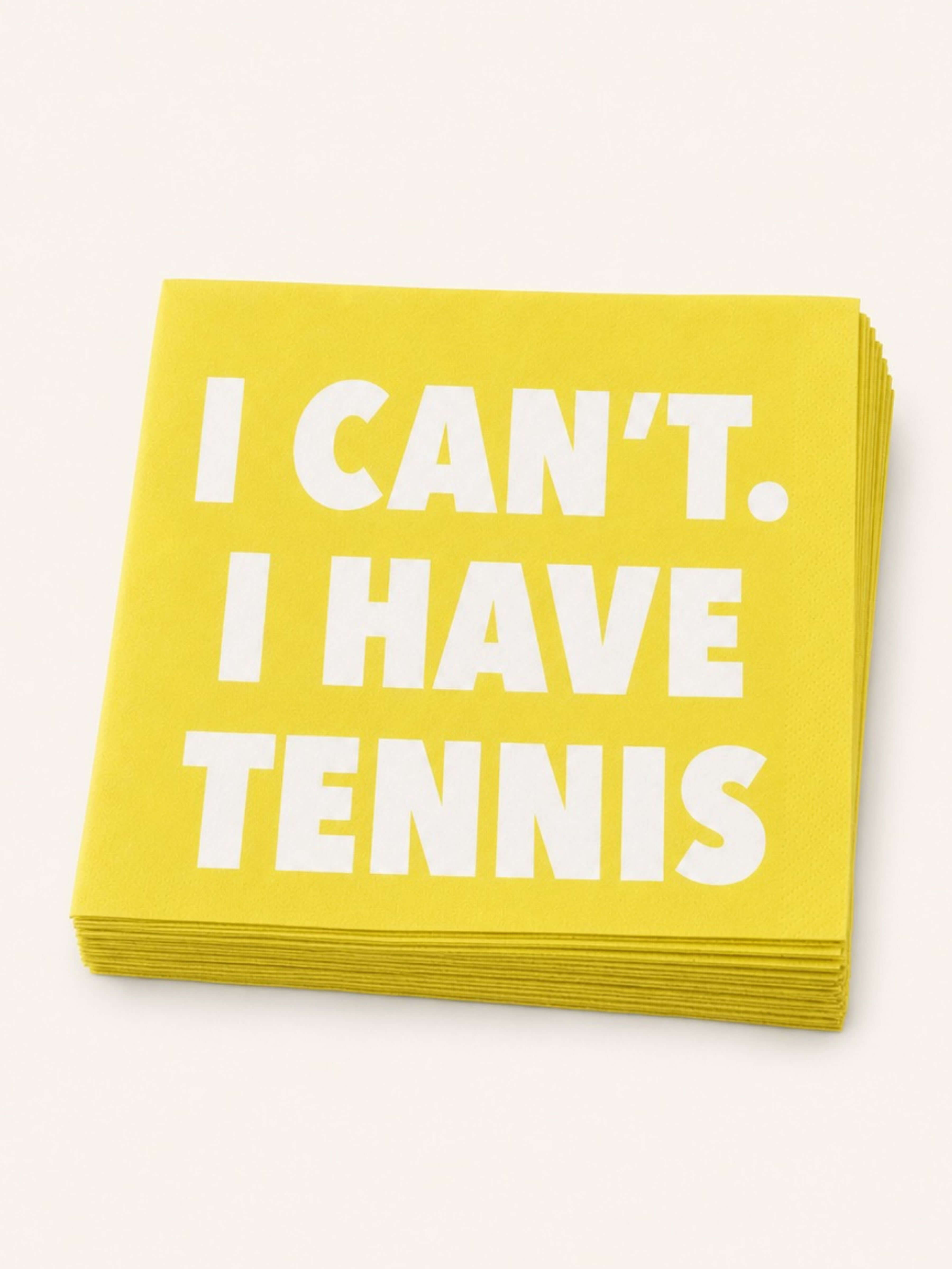 A stack of bright yellow square paper napkins with bold white text reading 'I CAN'T. I HAVE TENNIS' on a light cream background.