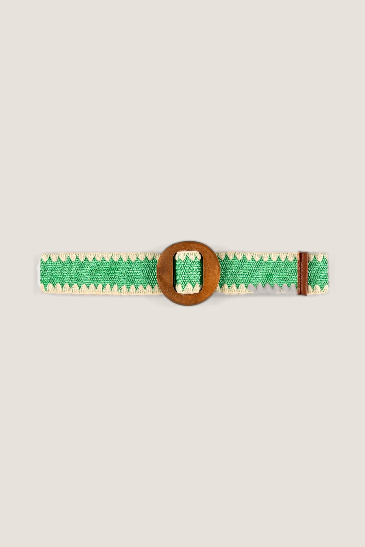 The Kayla Green Belt laid flat: green woven stretch band with cream zigzag trim and a round natural wood buckle.