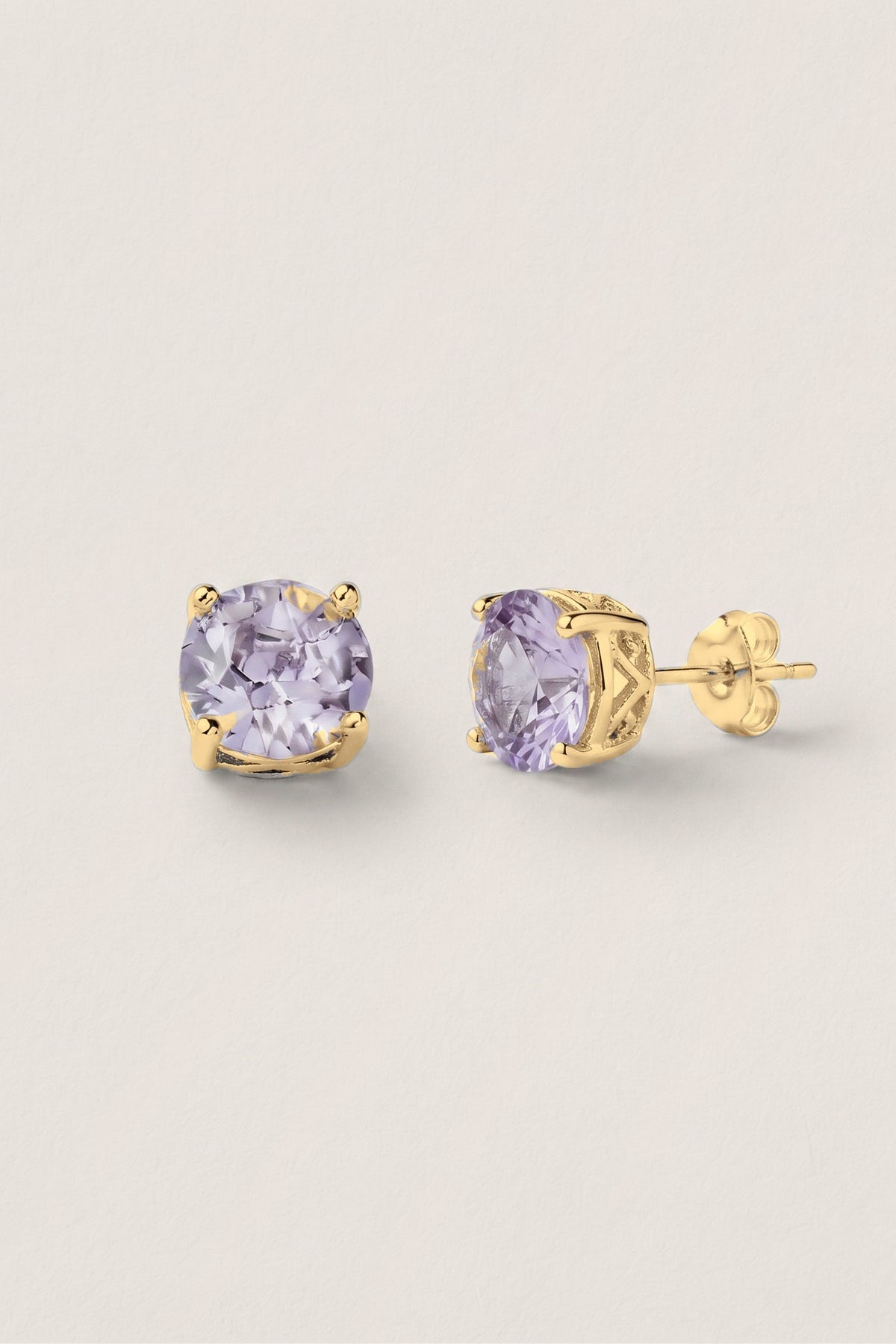 Lavender Sparkle Stud Earrings: a pair of round lavender crystal studs in a gold-tone prong setting, one turned to show the post.