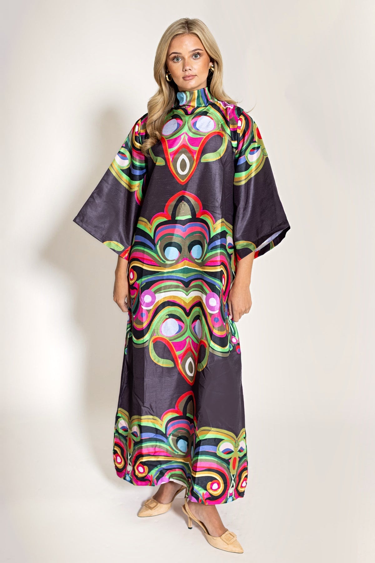The Merriweather Darling Dress by House of MBR from the front: a floor-length chocolate shantung caftan with a high stand collar and elbow kimono sleeves in a bold pink, green and blue print.