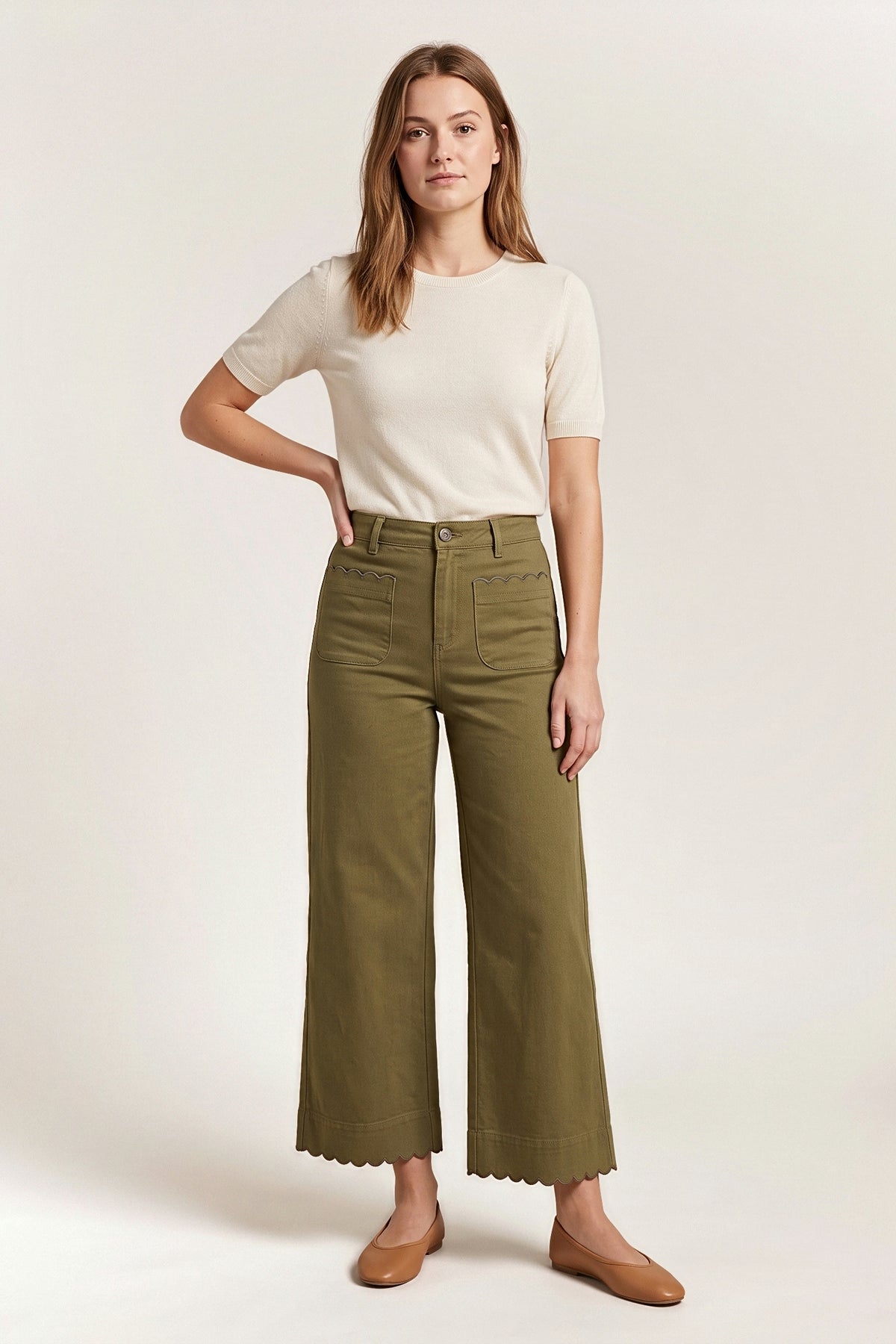 Front view of the olive Maribel wide-leg pants with scalloped patch pockets and scalloped hem, worn with a cream knit top.