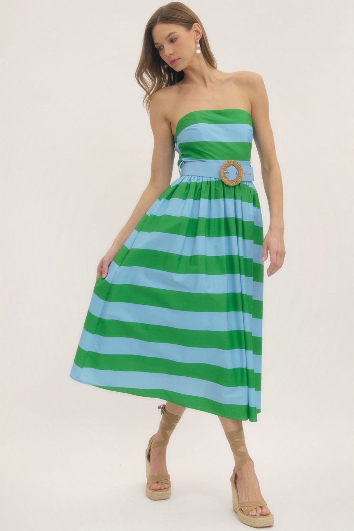 Three-quarter view of the Palm Beach striped strapless midi dress with a hand in the pocket.