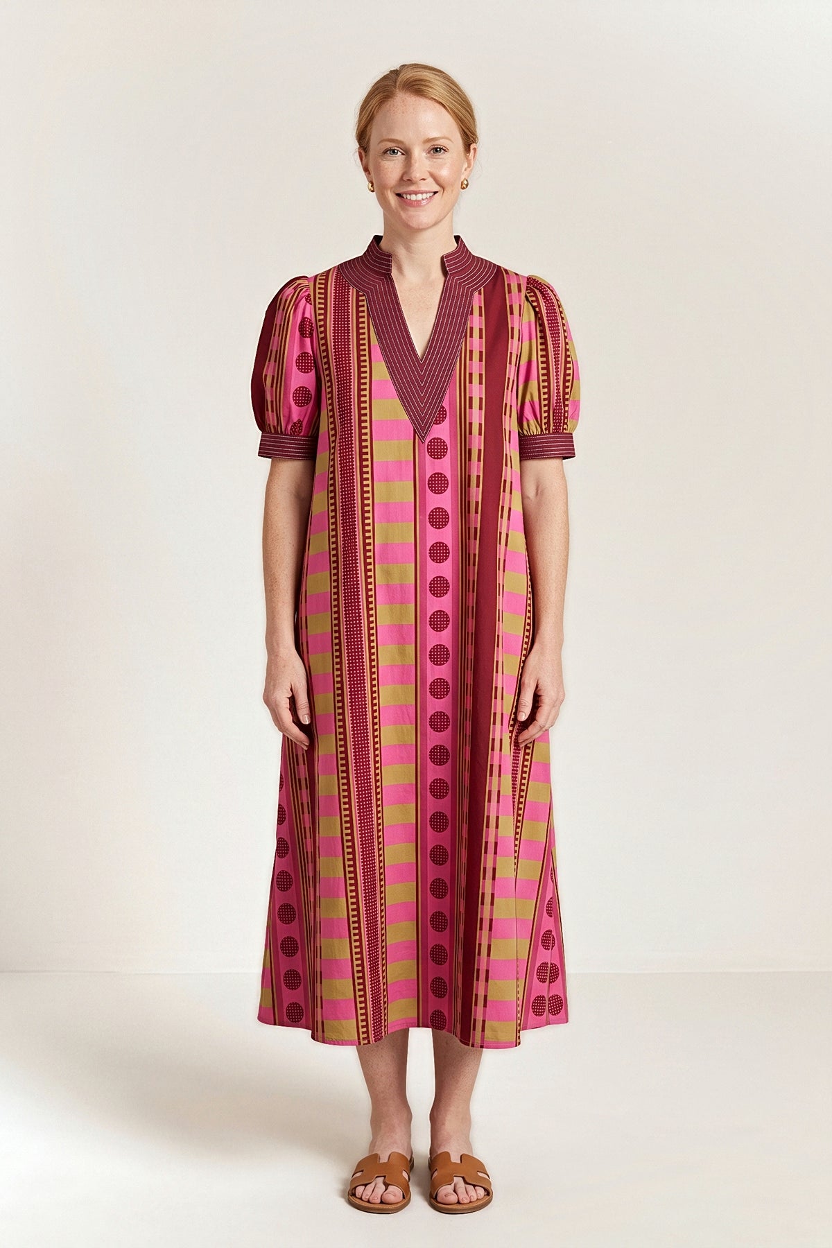 Front view of the Plum Blossom midi dress with a burgundy topstitched V neckline and puff sleeves.