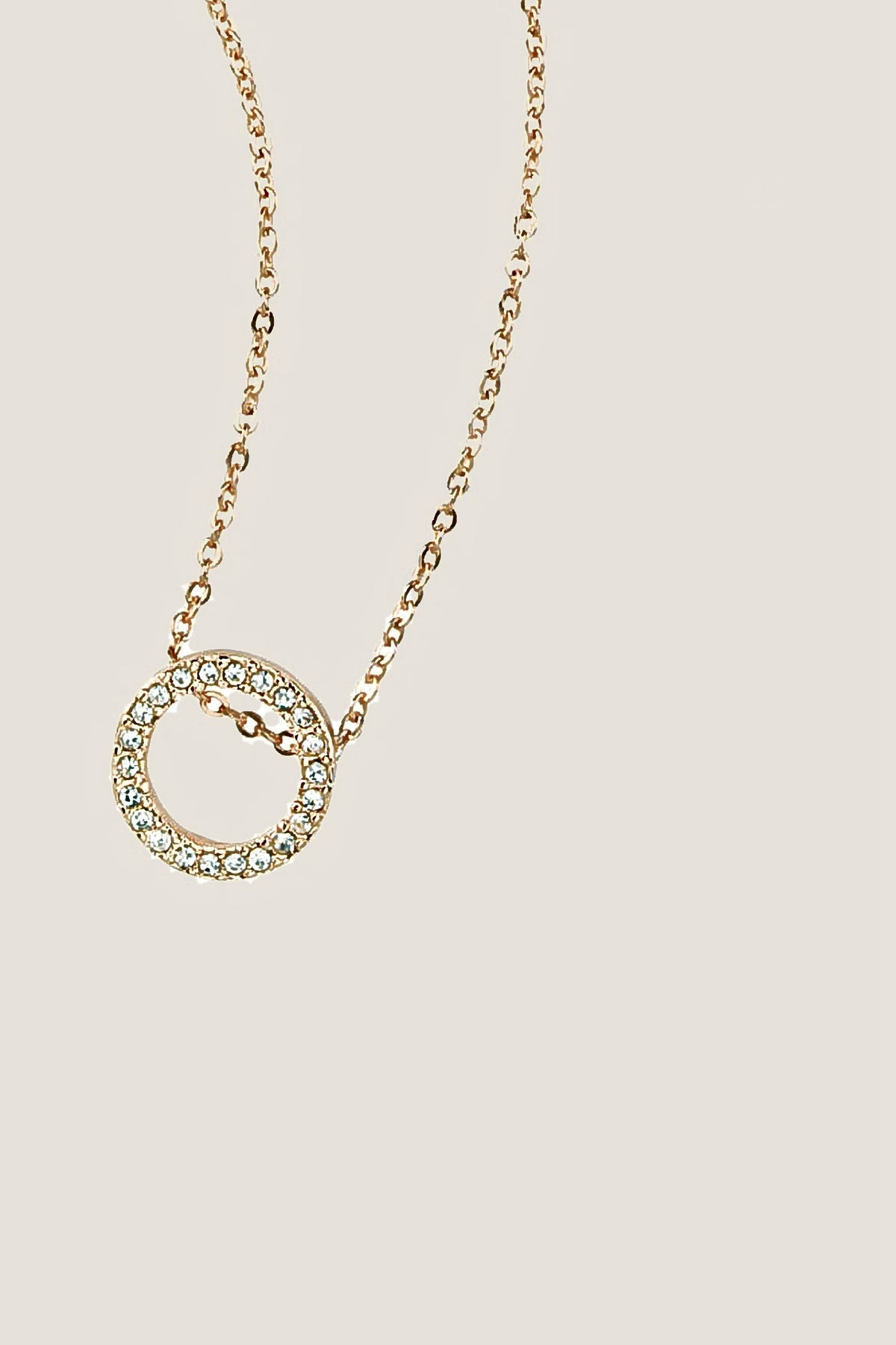 The gold Roo Necklace: a pave crystal circle pendant on a fine gold cable chain.