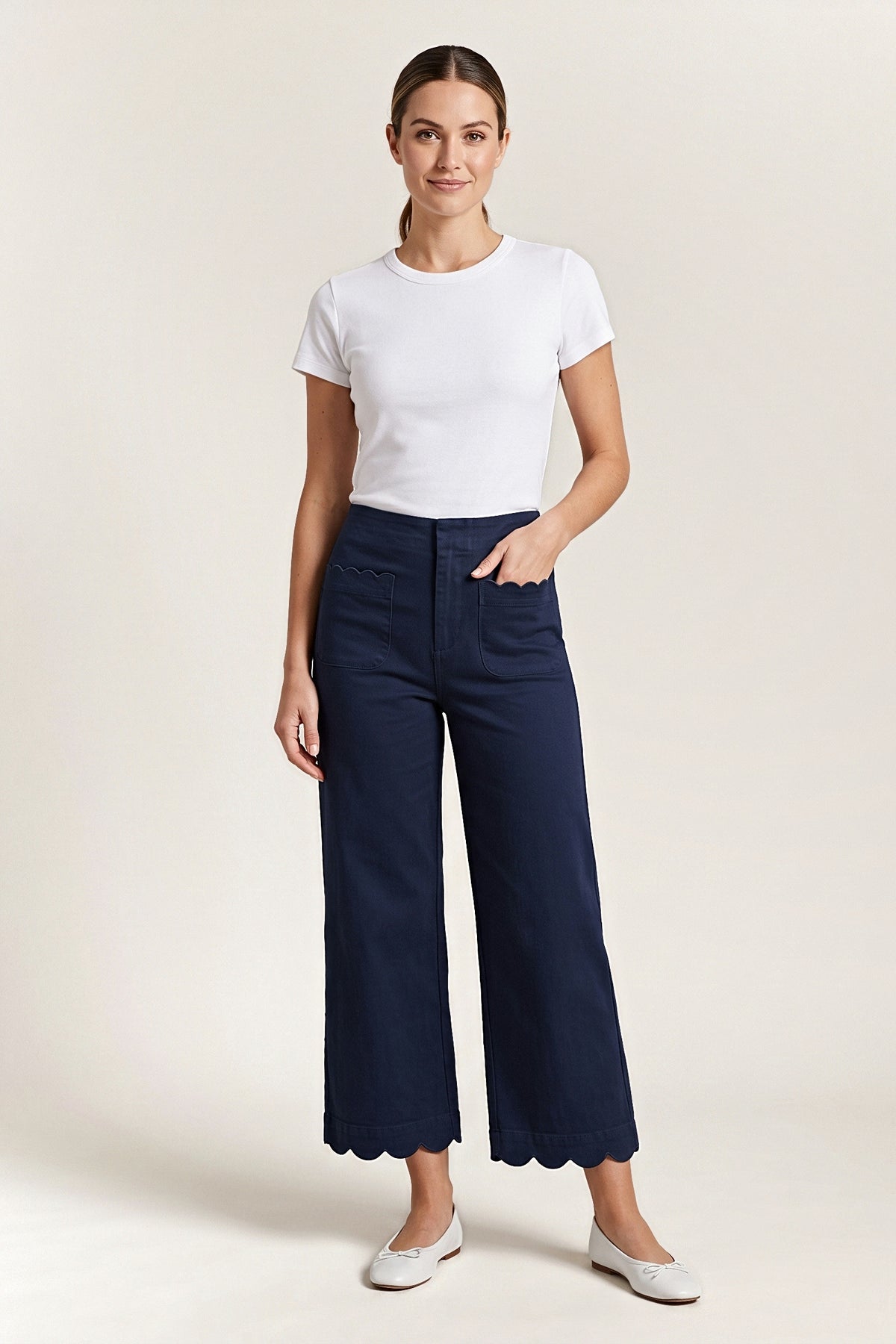Front view of the navy Maribel wide-leg pants with scalloped patch pockets and scalloped hem, worn with a white tee.