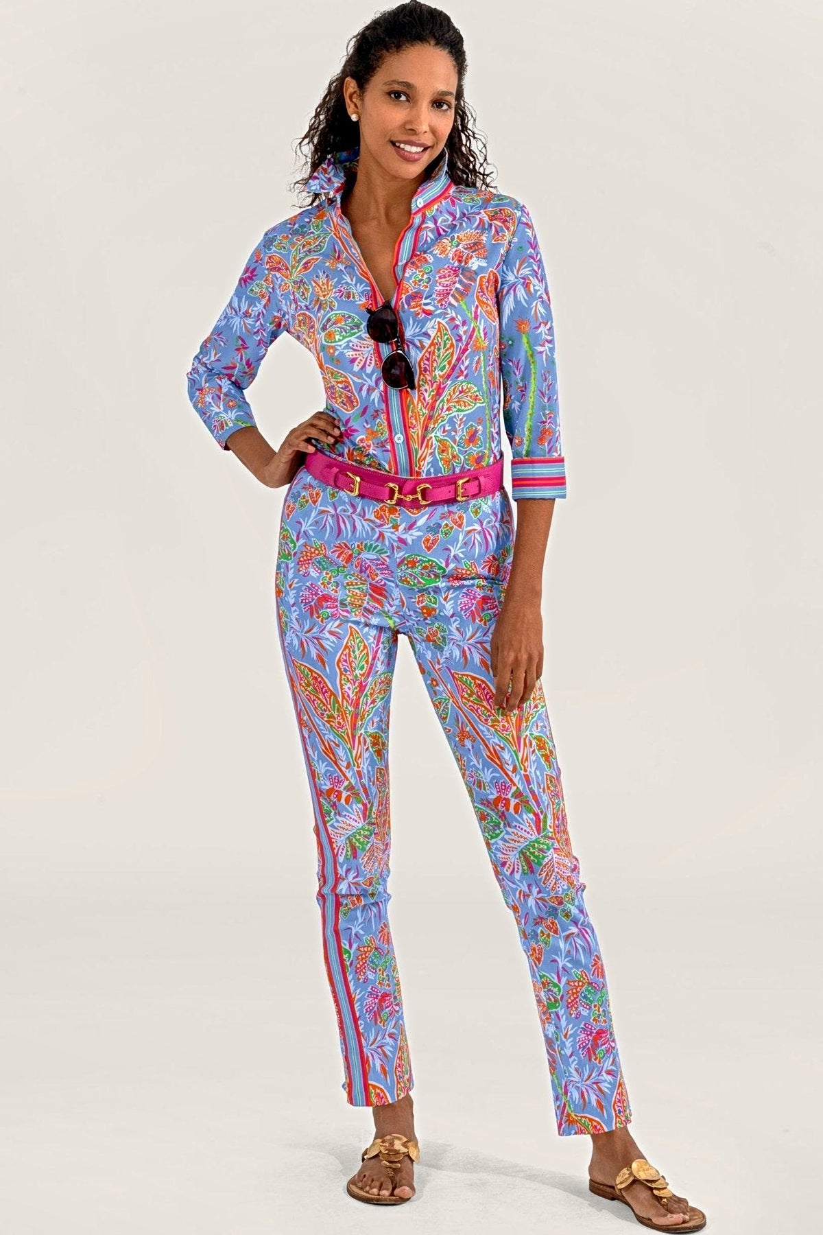 A woman in a matching periwinkle vine print shirt and pull-on pants with a pink belt.