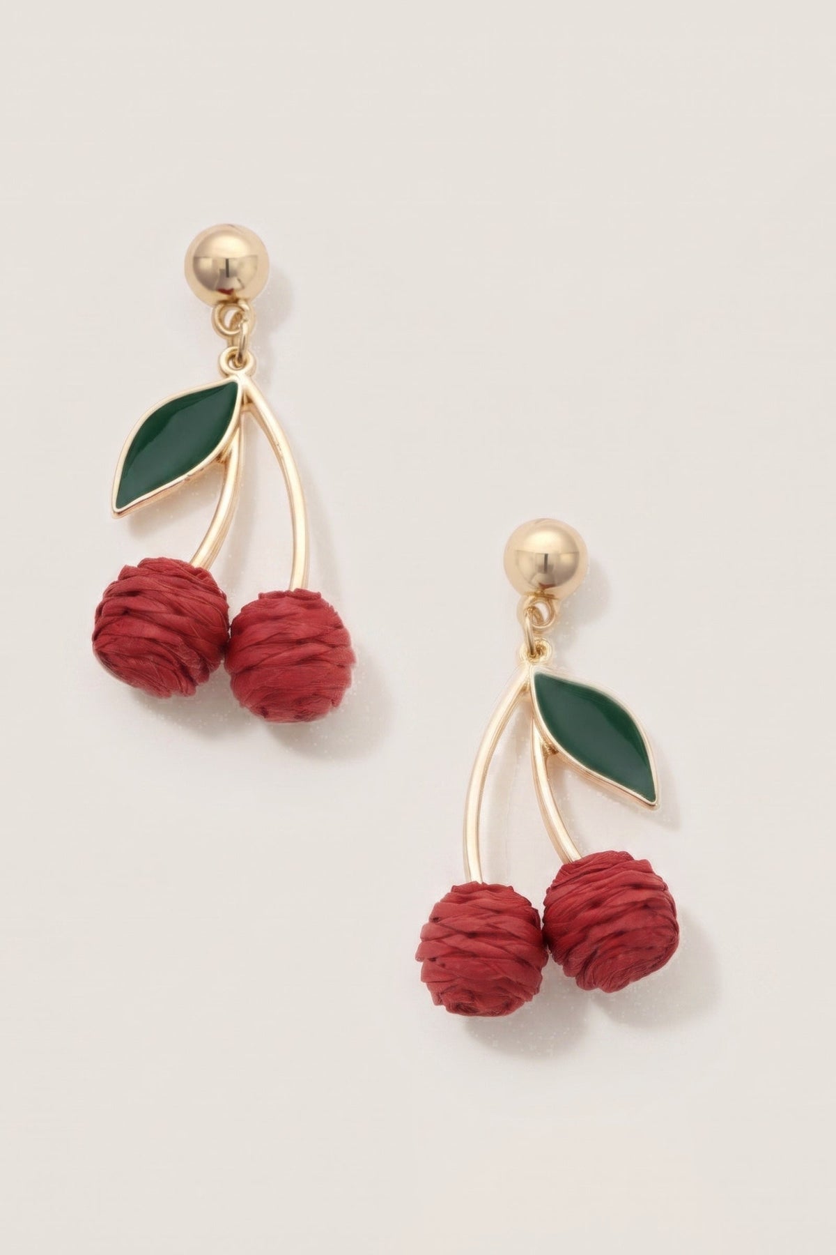 Cherry Red Raffia Drop Earrings on a cream background