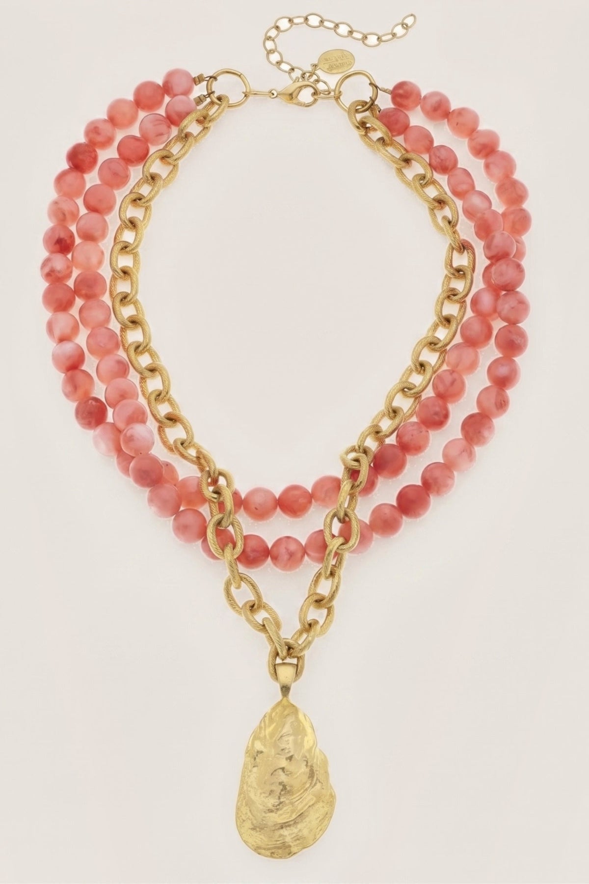 Gold Oyster and Coral Necklace on a cream background