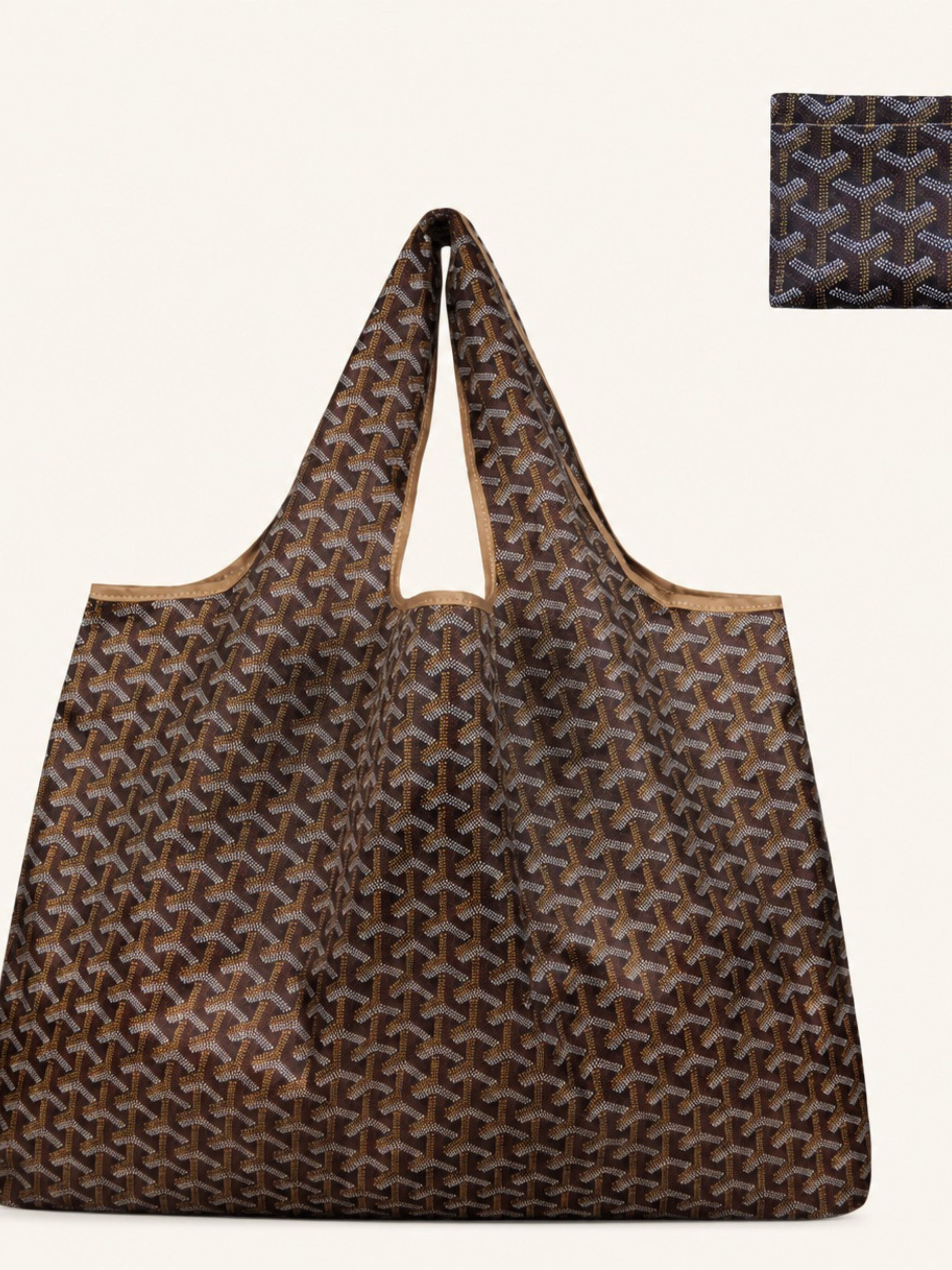 A brown Goyardine tote bag with its signature repeating chevron pattern, featuring tan leather trim and handles, shown against a light cream background with a small inset detail of the pattern in the top right corner.