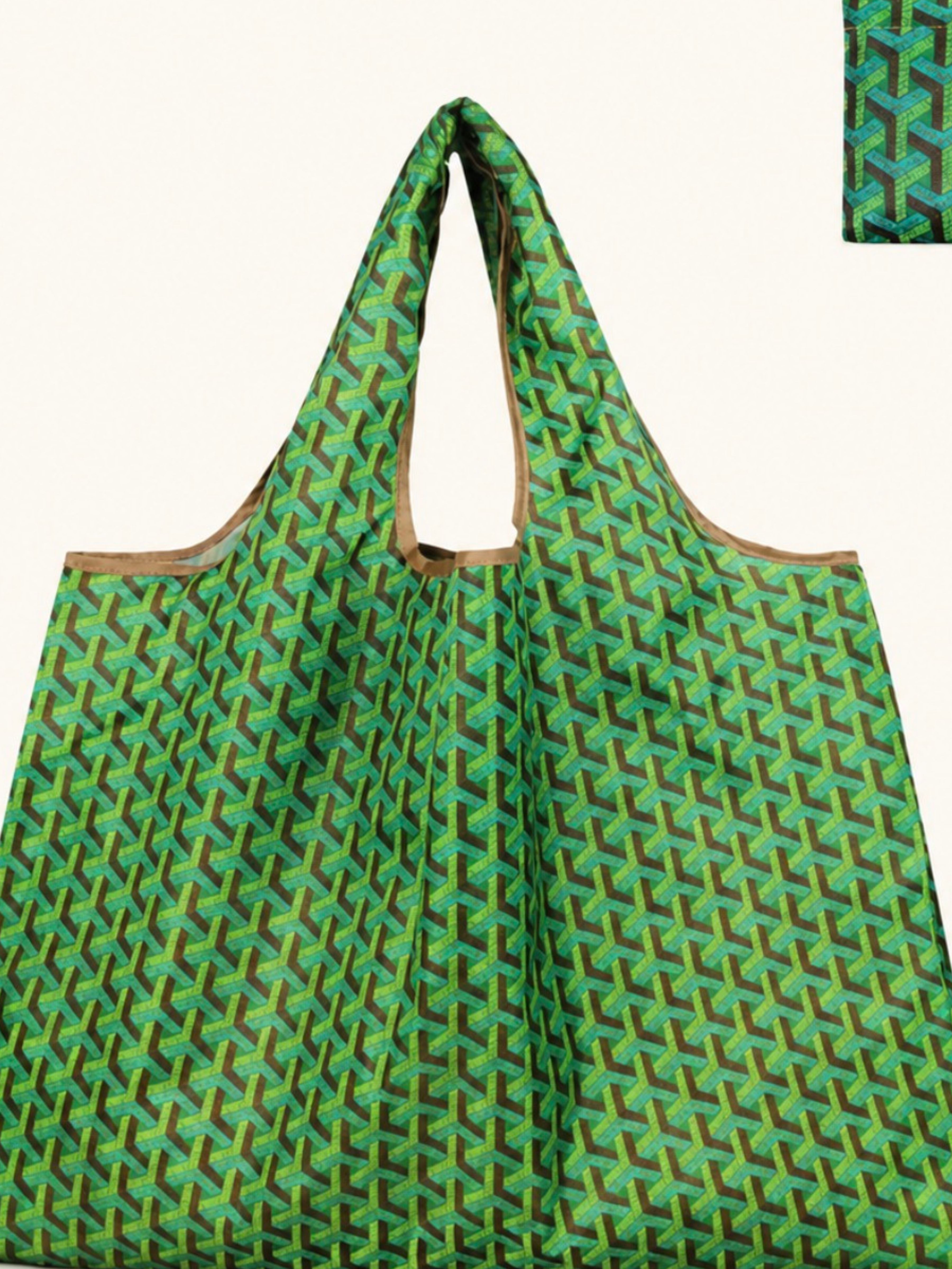 A green reusable tote bag with a repeating geometric pattern in shades of green and yellow, featuring tan handles, shown against a plain off-white background.