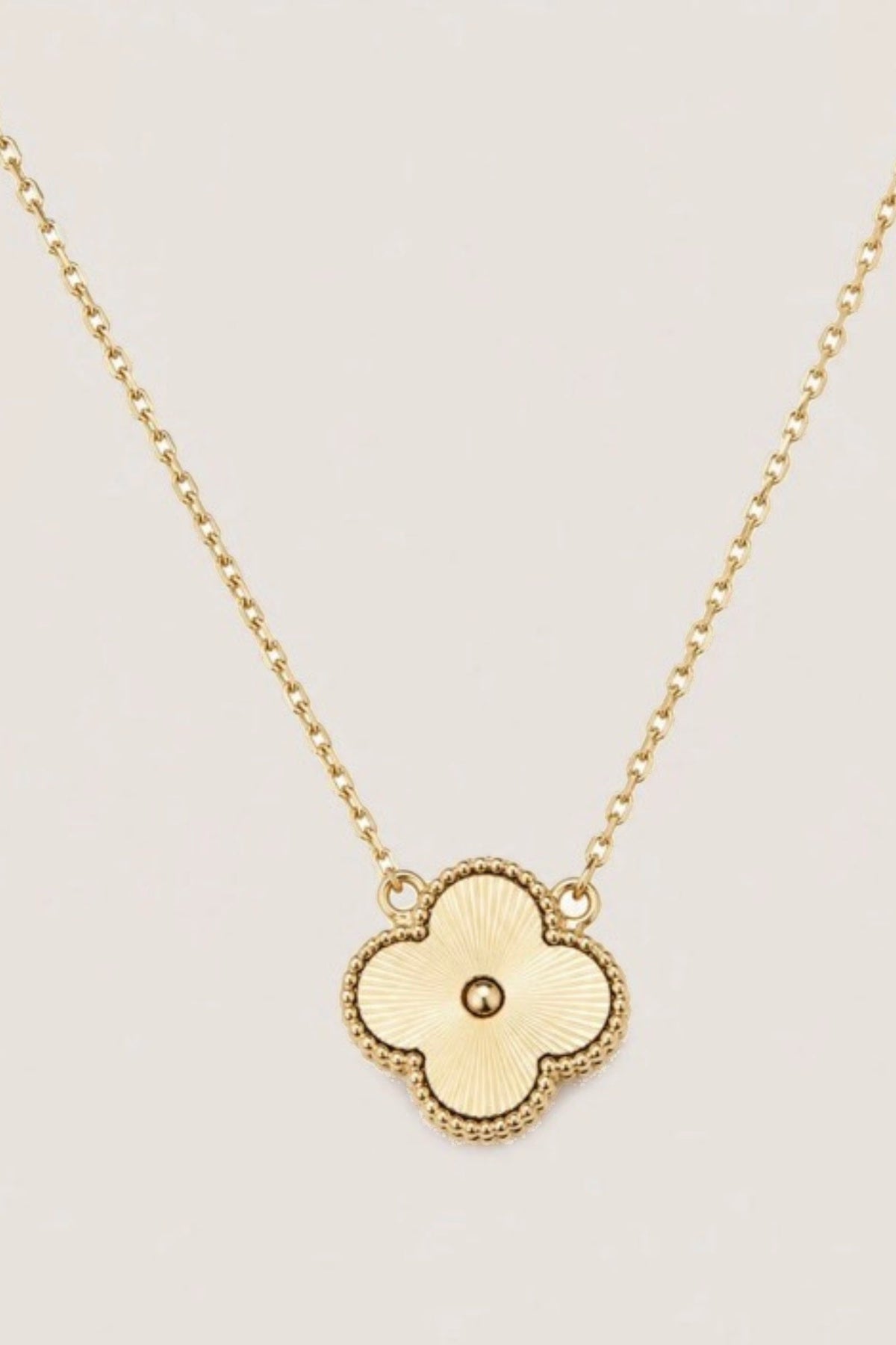 Foxy Gold Quatrefoil Necklace on a cream background