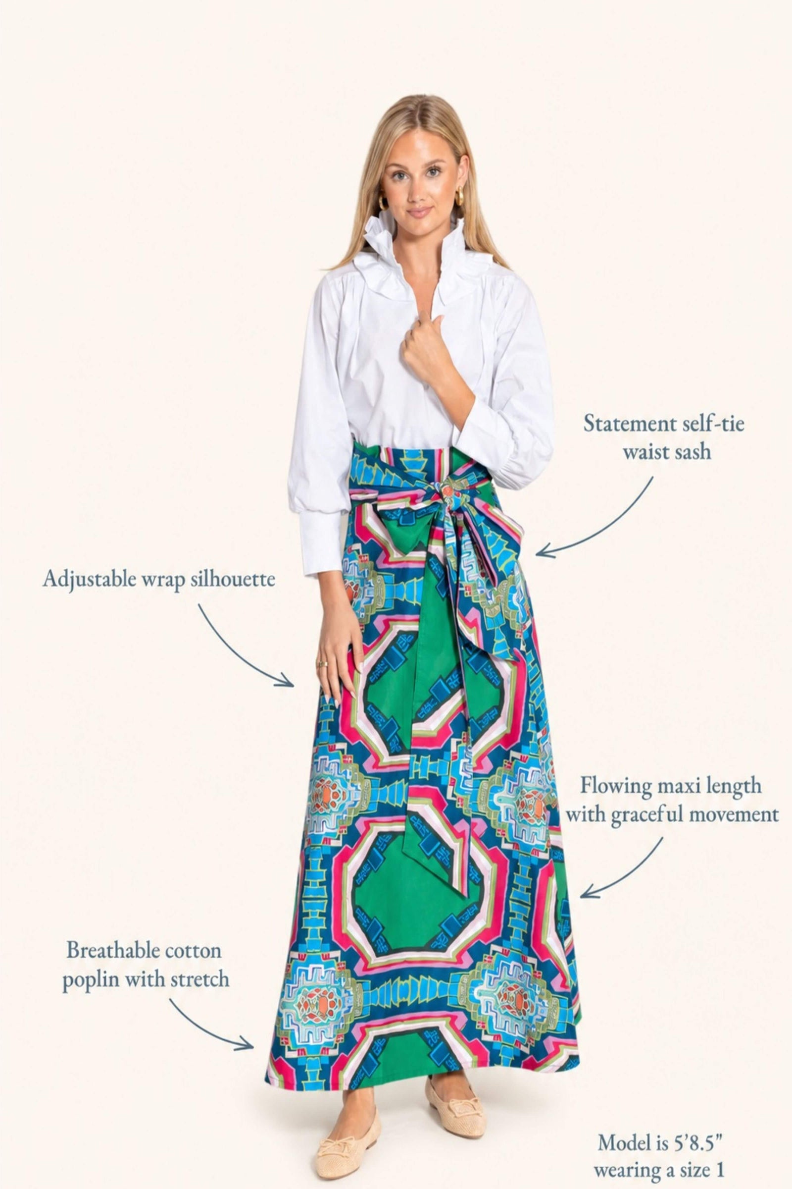 A woman modeling a long wrap maxi skirt with a colorful geometric pattern, styled with a white button-up shirt. The image features text callouts pointing to features of the skirt and shirt on a solid light beige background.