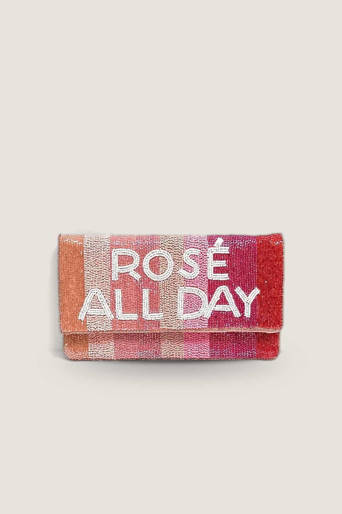 The Rosé All Day Beaded Clutch, a fold over clutch beaded in coral, pink and red stripes with white beaded lettering, shown front on.