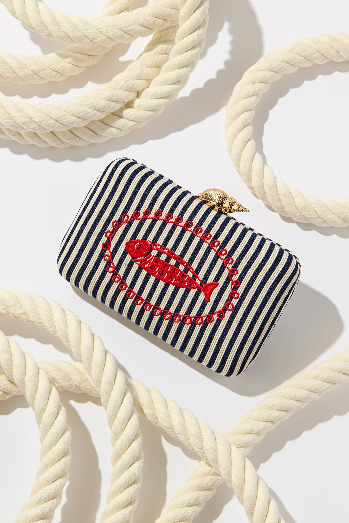 The Navy Marina minaudiere clutch styled among coils of cream rope.