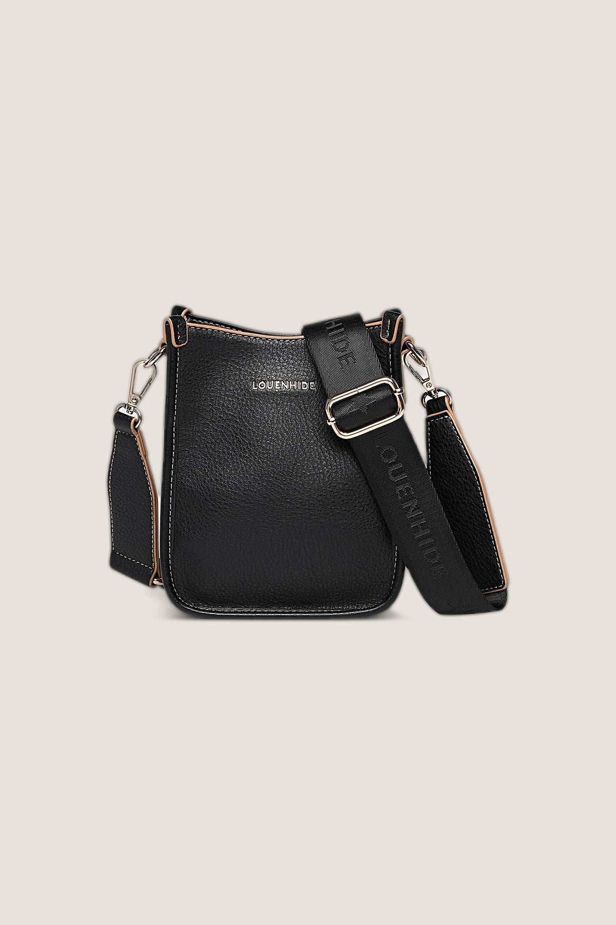 Black Parker Crossbody Bag in pebbled black vegan leather with tan edge stitching and a black webbing strap, front view on a warm greige backdrop.