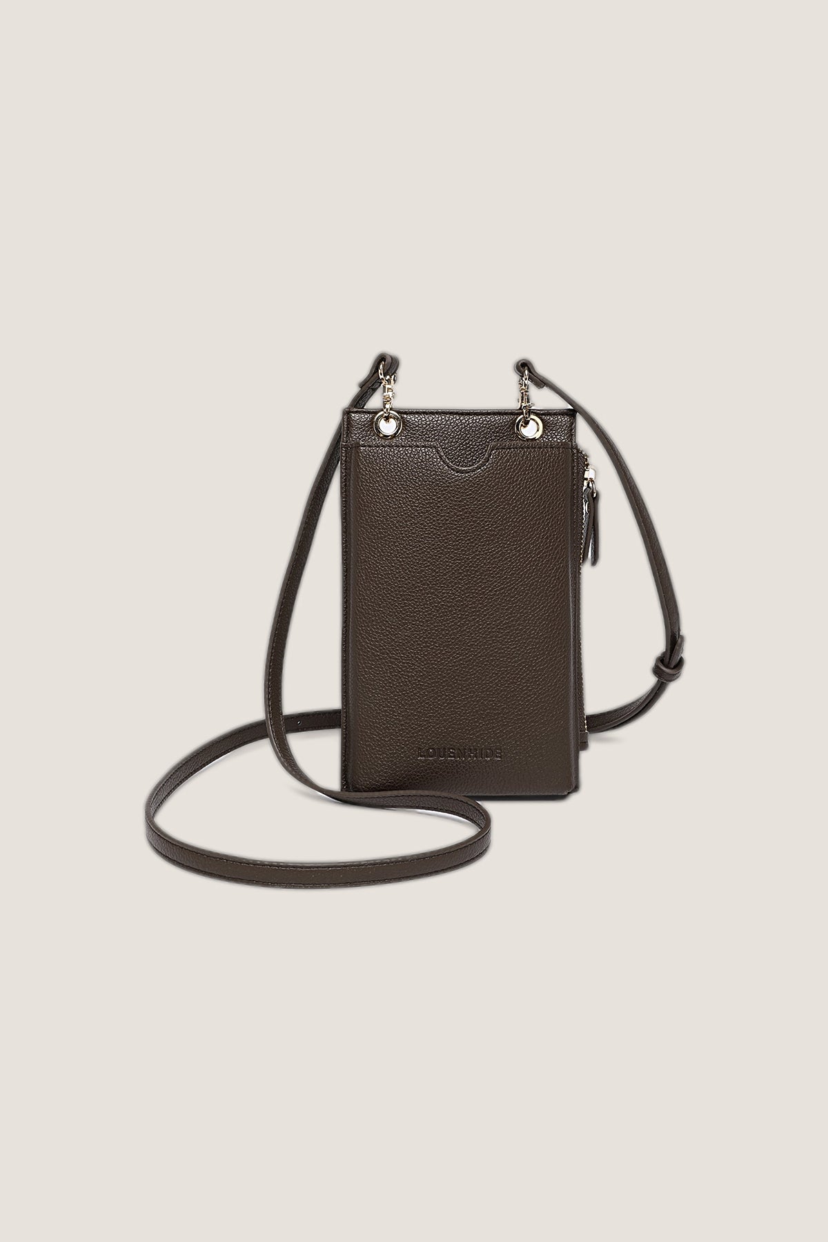 Chocolate Suki Phone Crossbody Bag in pebbled chocolate brown vegan leather with light gold hardware and its crossbody strap, front view on a warm greige backdrop.