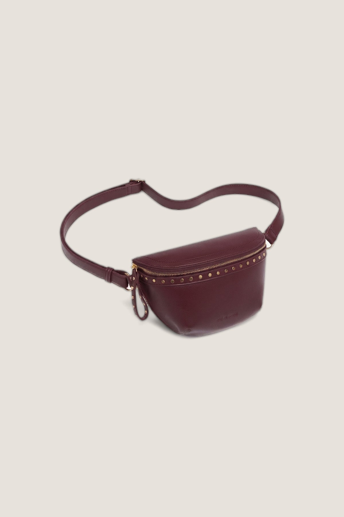 Three-quarter view of the Cassidy Burgundy Belt Bag showing its curved shape and stud trim.