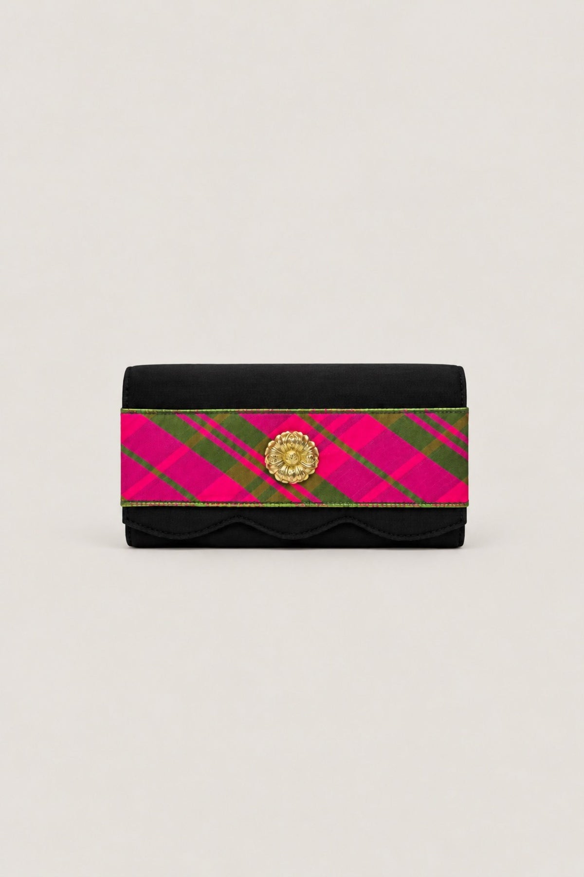 A black wallet with a vibrant pink and green diagonal plaid stripe across the front, accented by a gold-tone circular clasp, set against a plain light beige background.