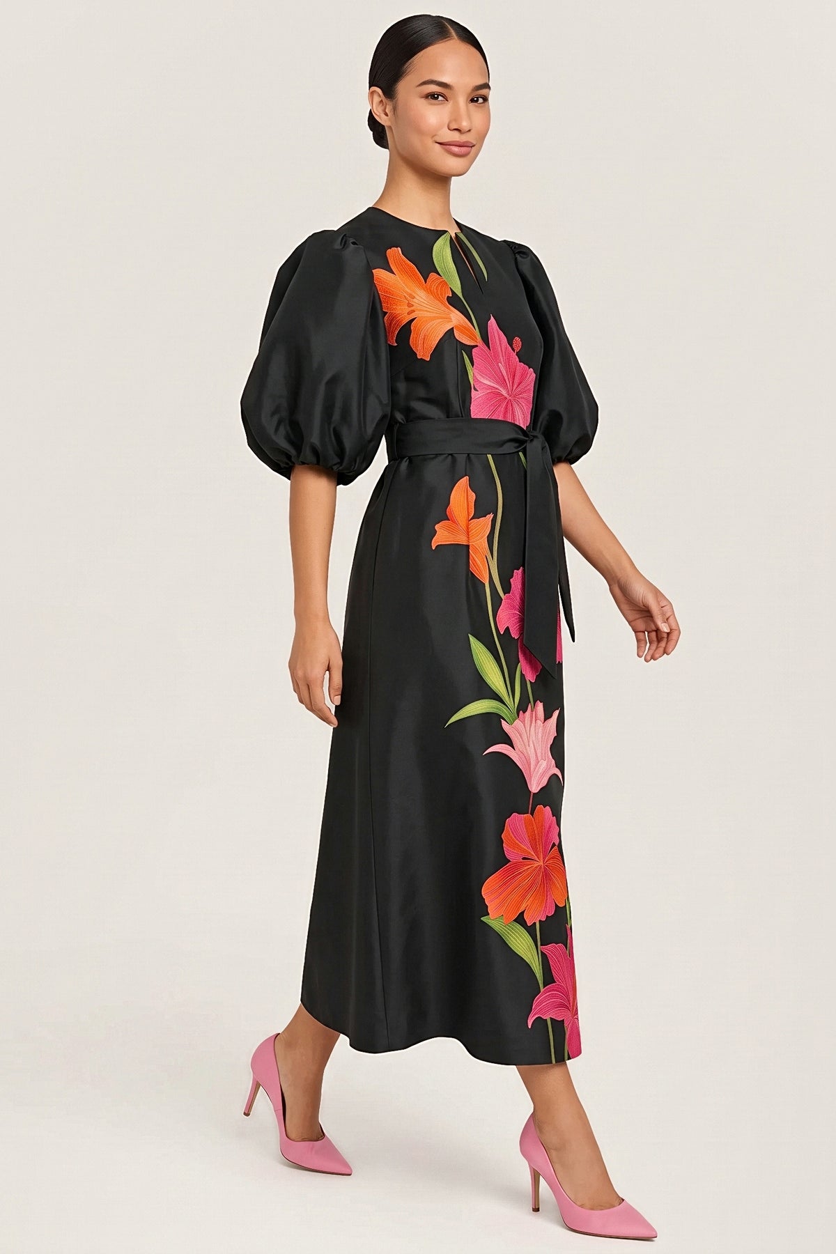 Three-quarter view of the Botanical Noir dress in motion, showing the balloon sleeve and the floral print.