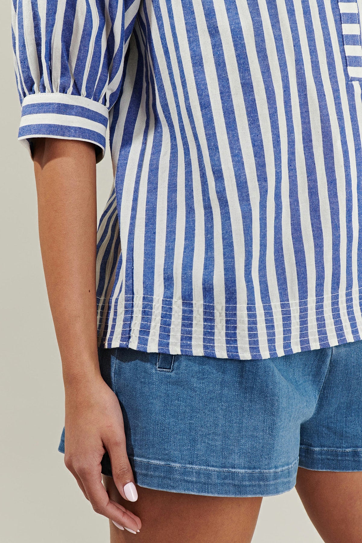 Close-up of the Catana Striped Split Neck Top showing the banded puff sleeve cuff and the stitched hem in blue and white stripes
