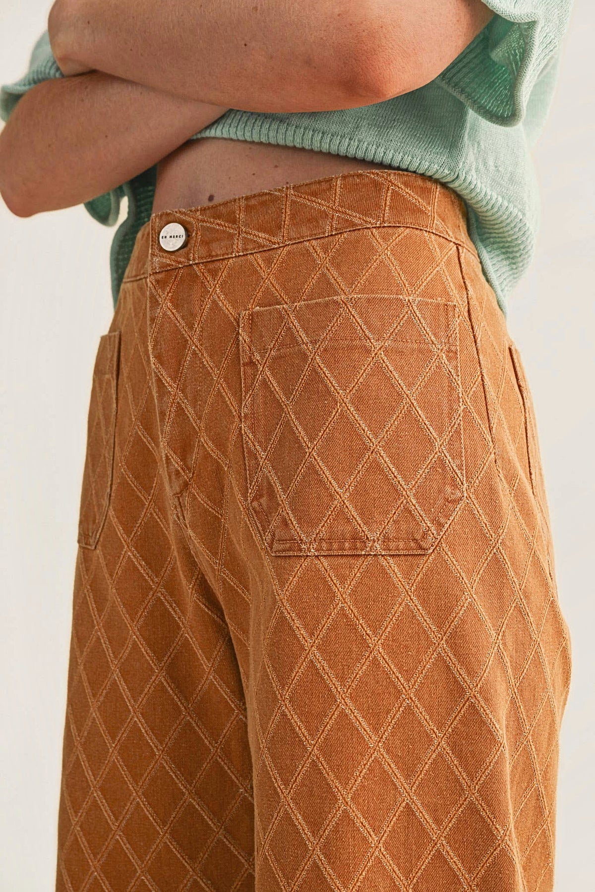 Close-up of the diamond quilted texture, contrast stitching, front patch pocket and button.