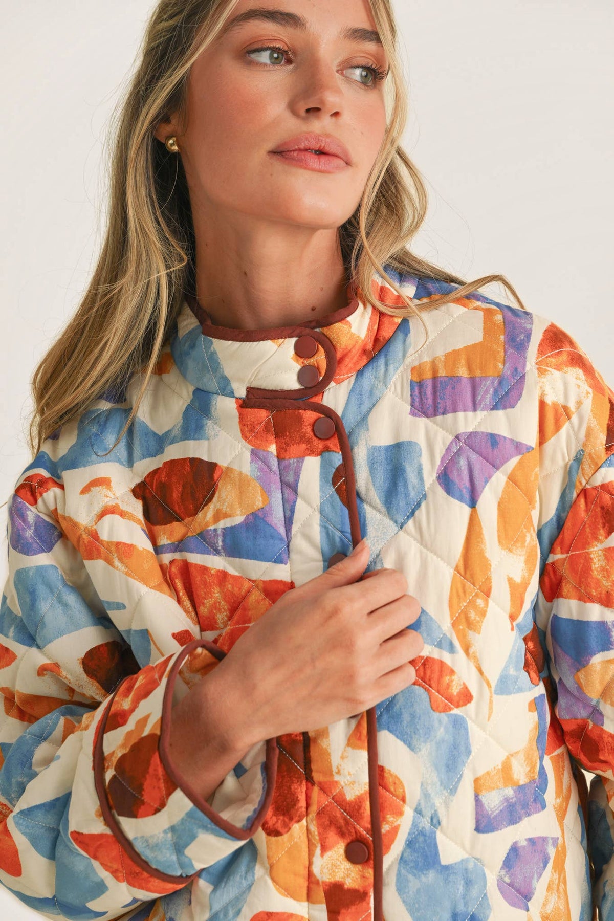 Close-up of the Exclusive Print Quilted Jacket showing the diamond quilting, stand collar and rust contrast binding
