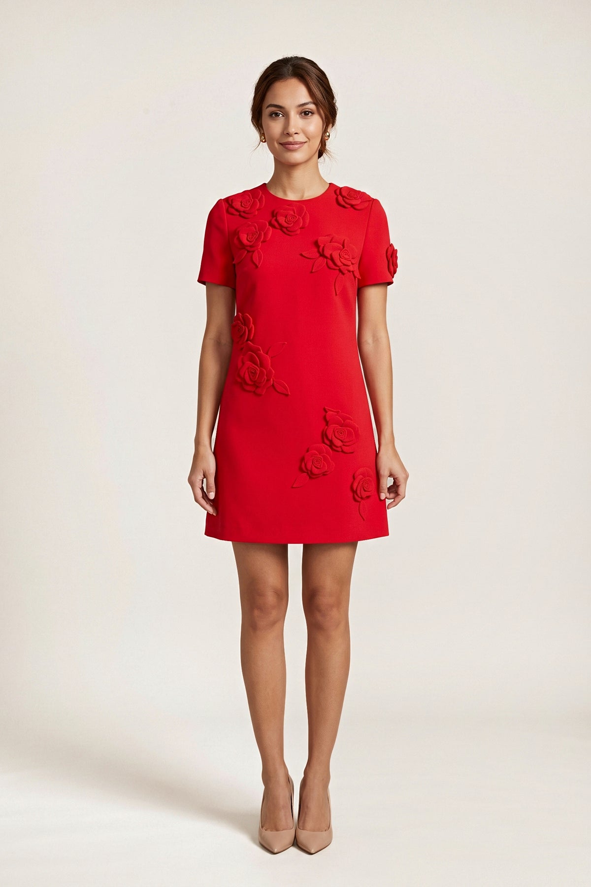 Front view of the red short-sleeve shift dress on a model, with sculpted 3D fabric roses on the shoulders, sleeve and skirt.