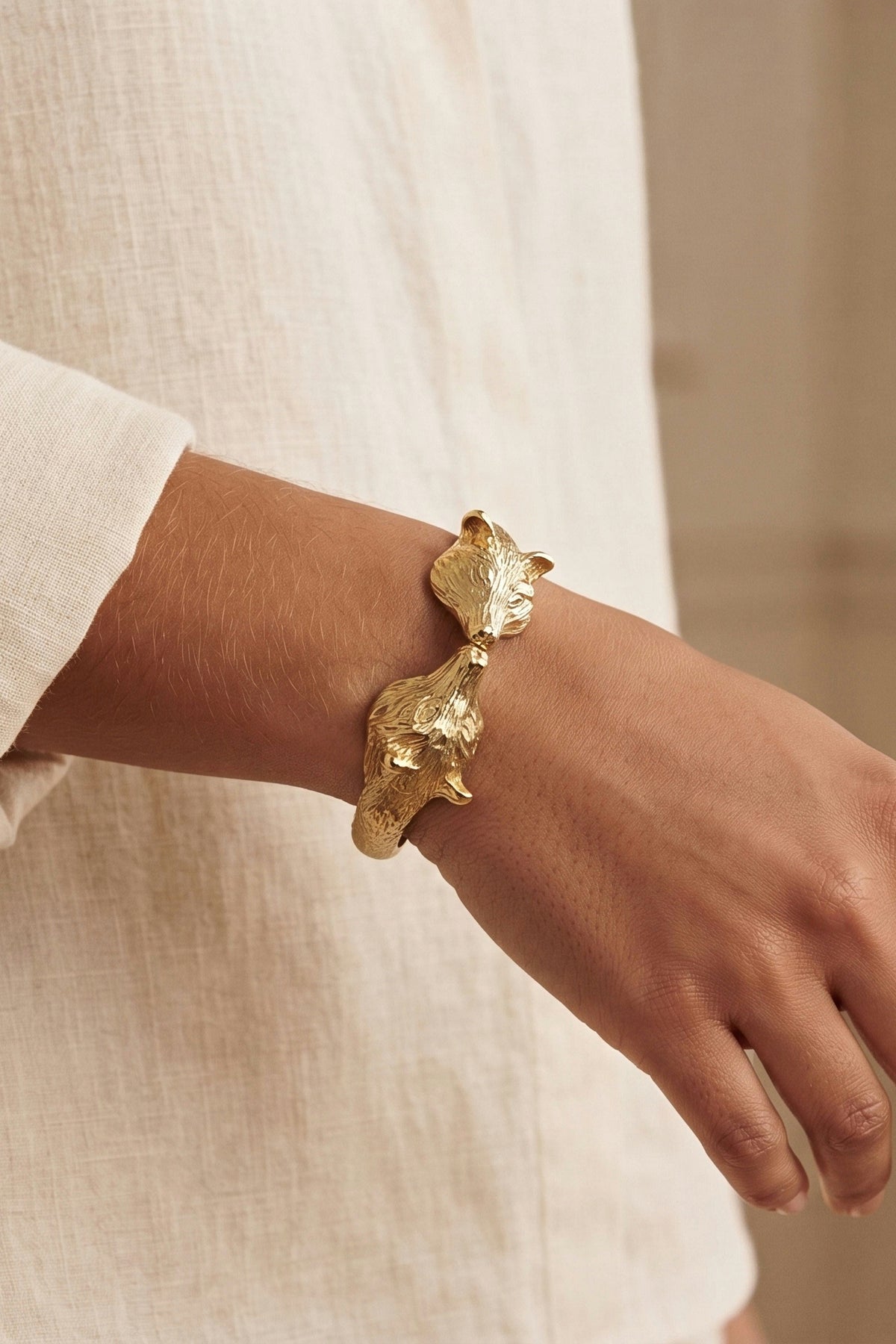 Golden Fox Hinged Bracelet worn on the wrist with a white linen shirt, showing its size.