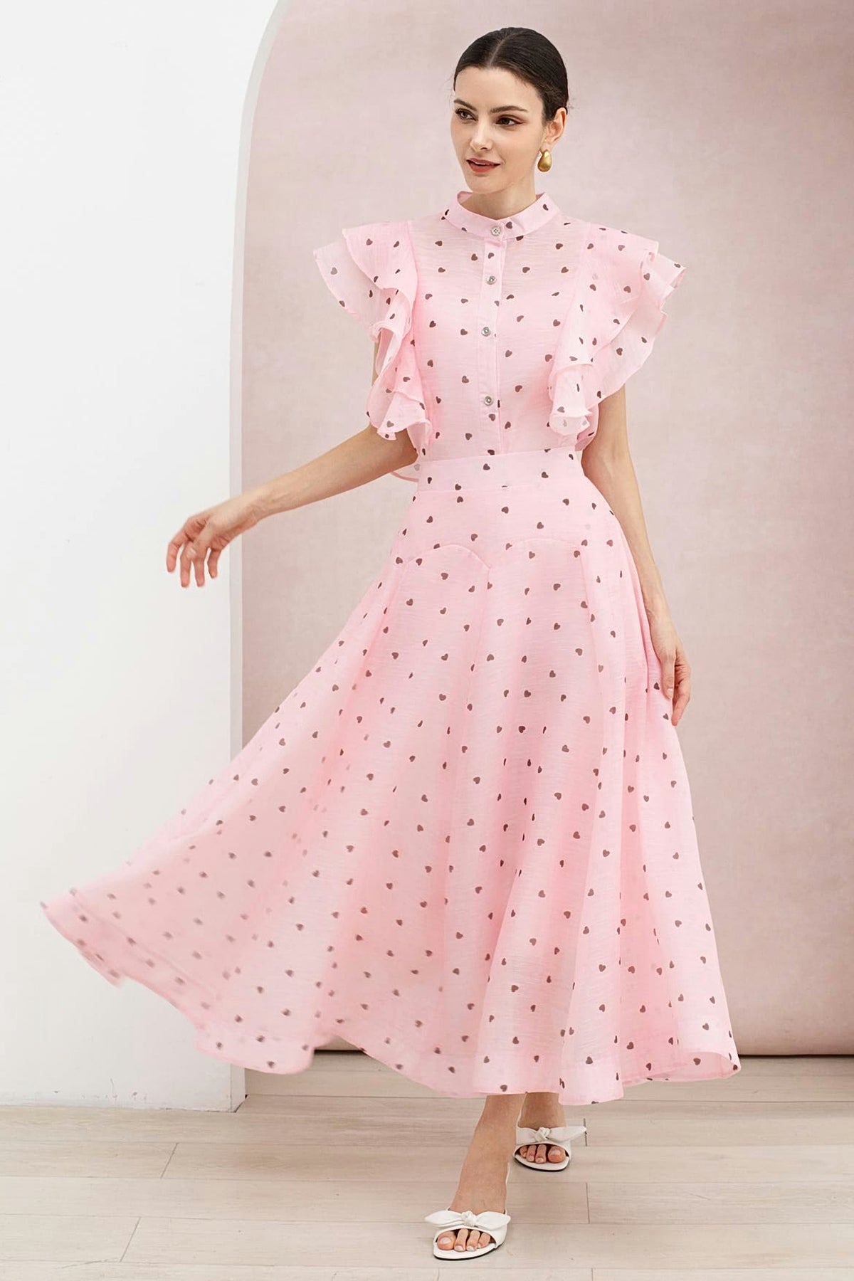 The blush pink heart print organza maxi skirt in motion, worn with the matching ruffle-shoulder top.