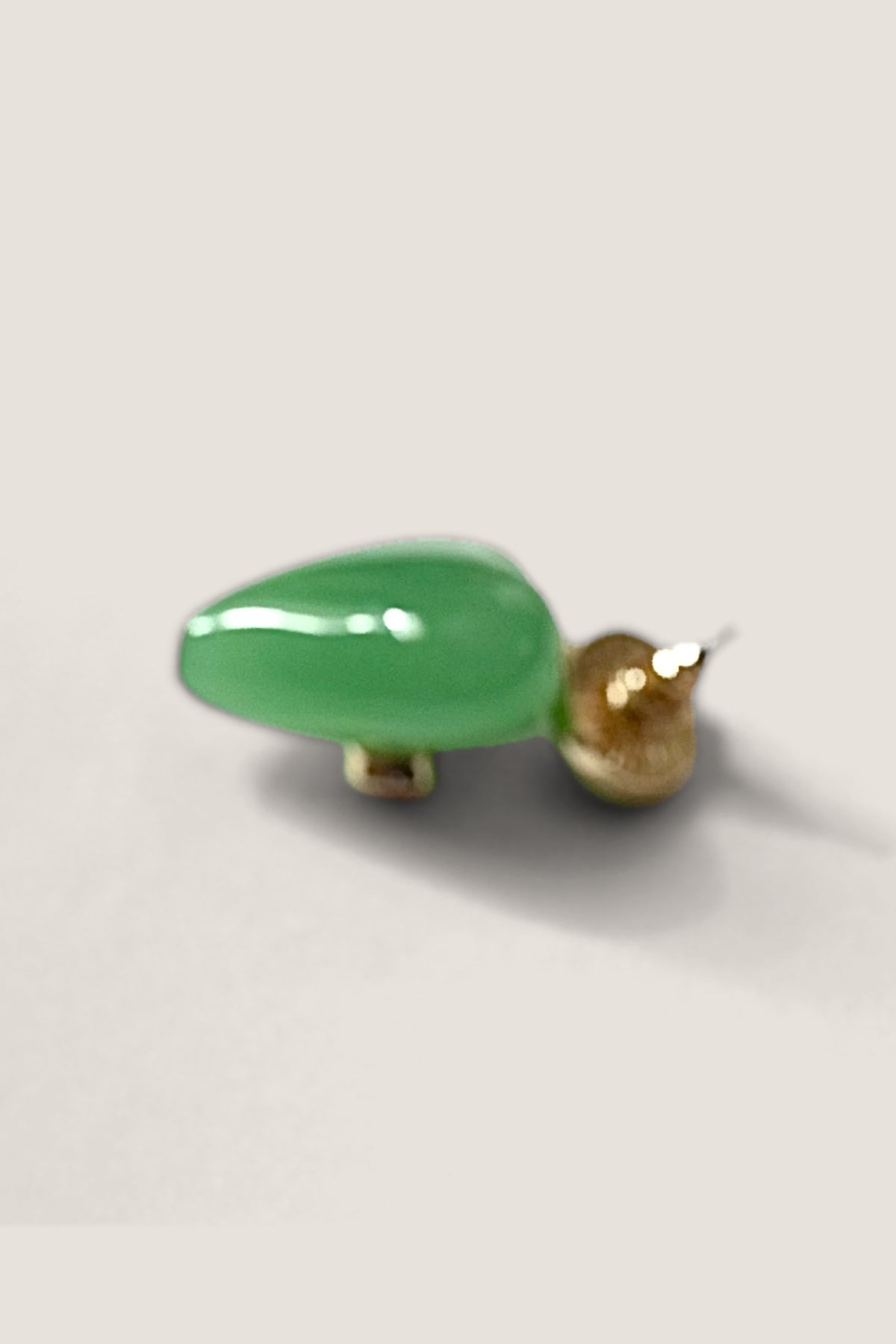 Side view of the jade green Lucky Heart earring showing the gold post and back.