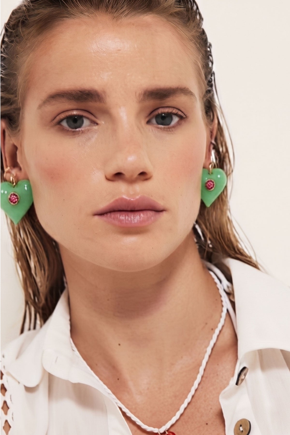 A woman wearing earrings with an evil eye in the middle of them 