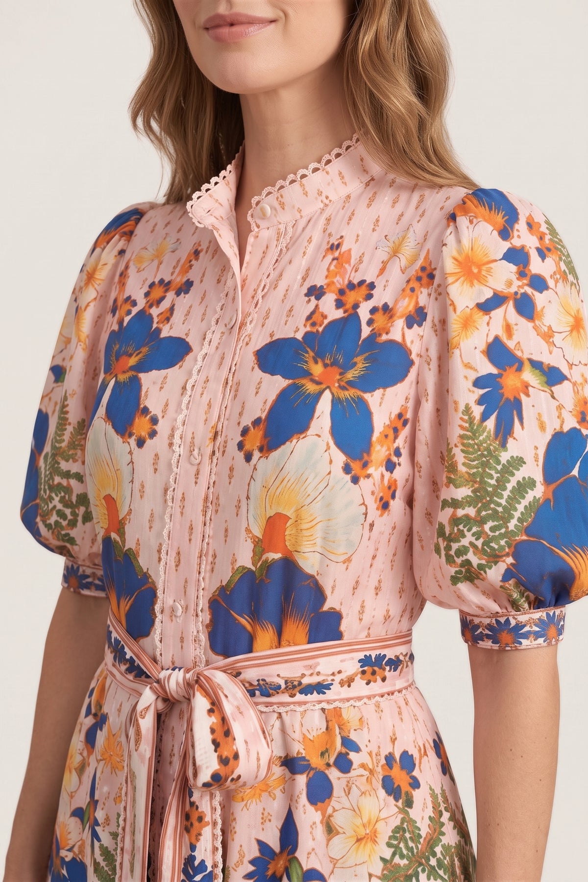 Close-up of the Marseille Garden Dress showing the lace-trimmed stand collar, button placket, puff sleeve with banded cuff and the cobalt and orange floral print