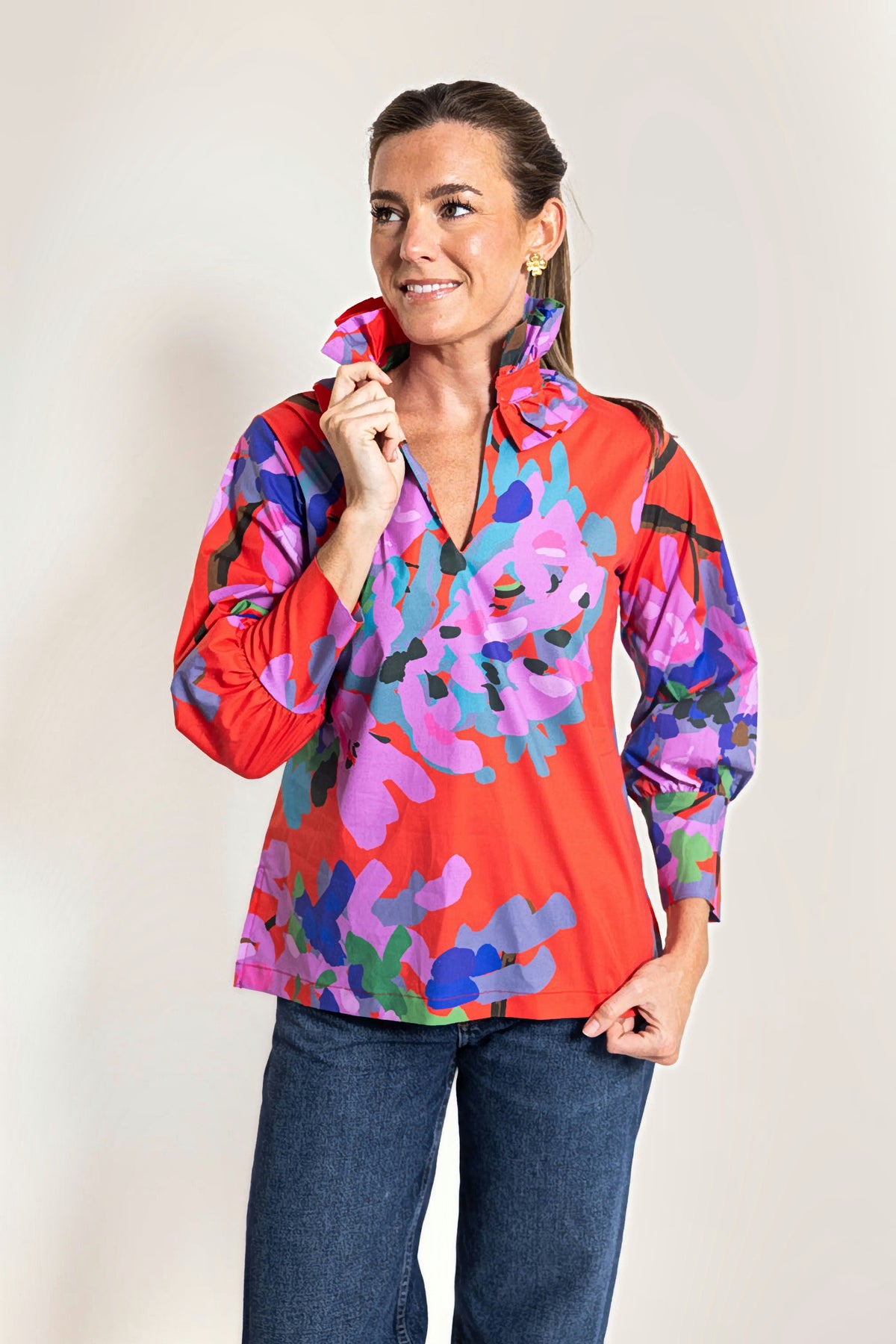A woman in the Miss Scarlet Harper Estate Top, three-quarter view, touching the pleated ruffle stand collar