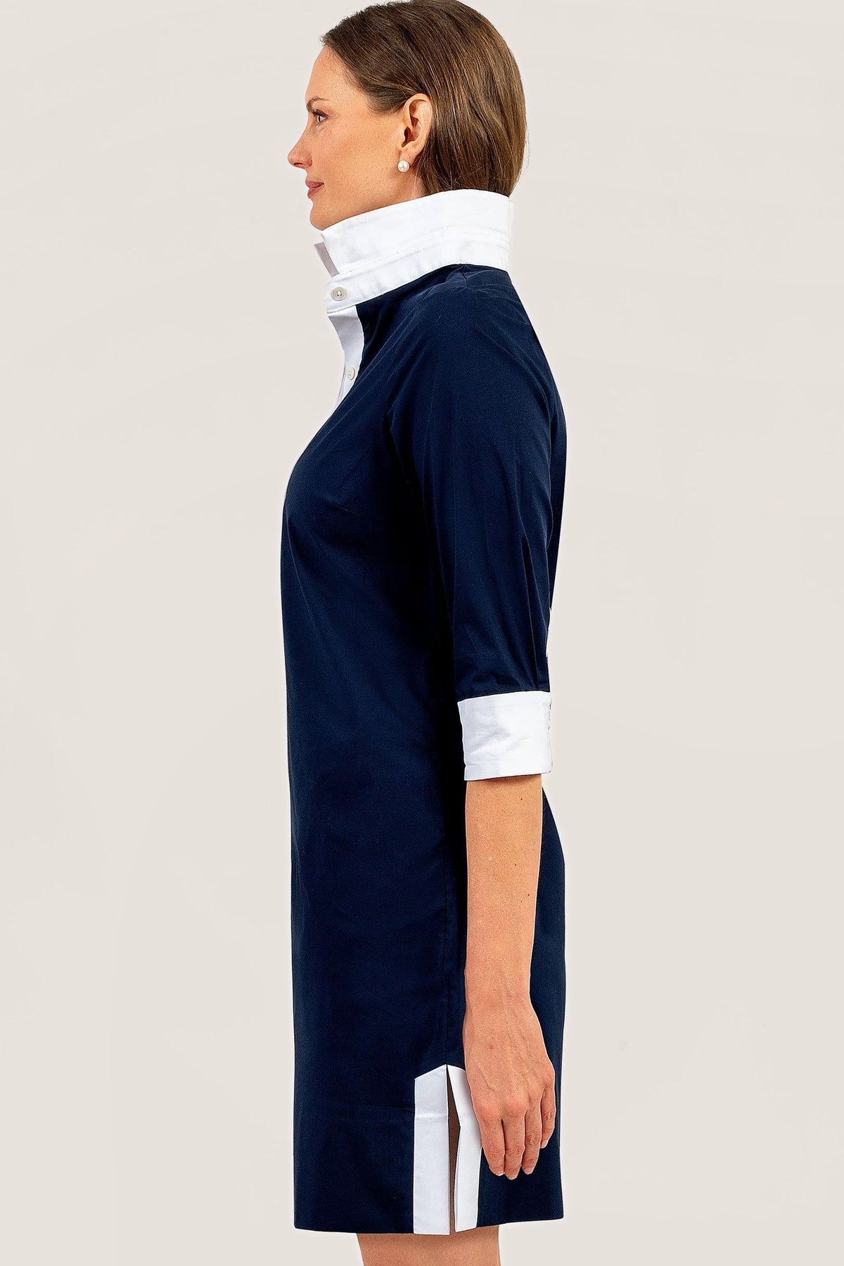 Side view of the navy tunic dress, showing the white collar and side slit.