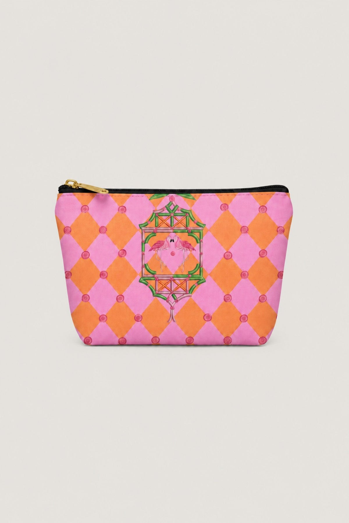 A small zippered pouch with a pink and orange harlequin pattern, featuring a central green and gold decorative crest with a pink face, set against a light gray background.