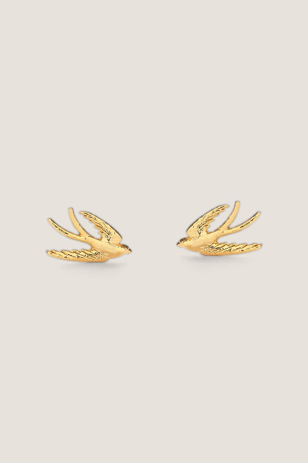 The gold Swallow Bird stud earrings shown face-on side by side, showing the engraved feathers.
