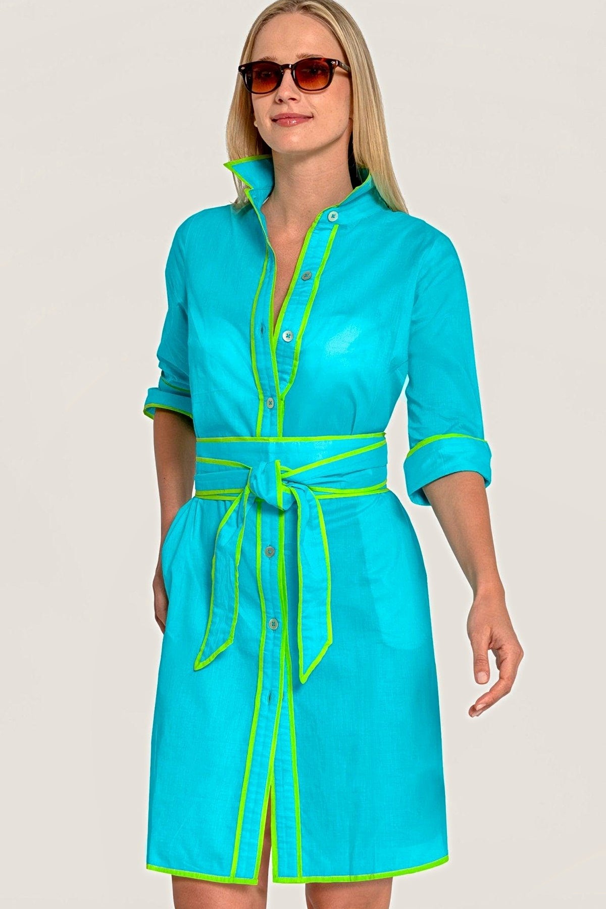 Front view of the turquoise shirt dress with lime green piping and a tie belt.