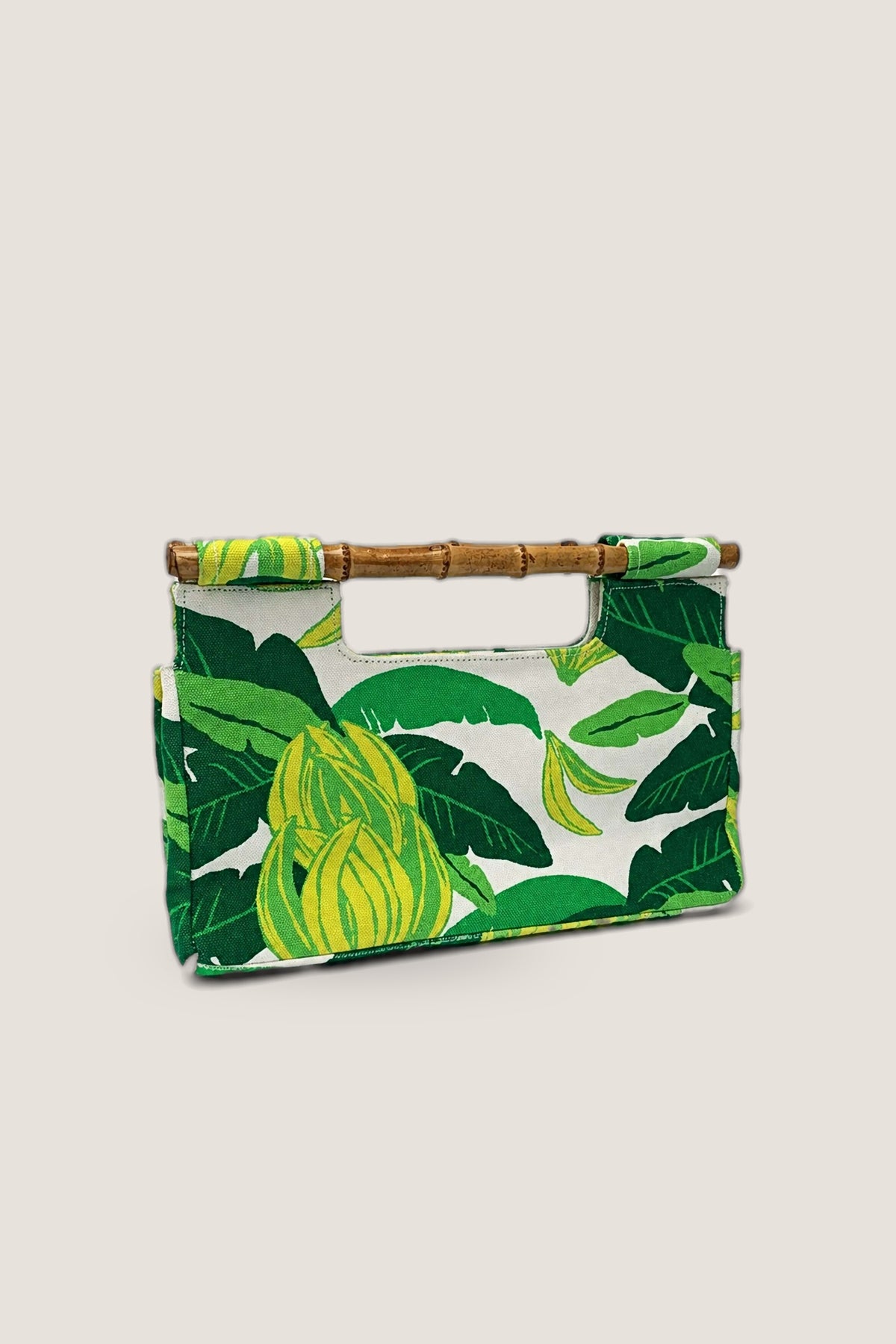 The Banana Bamboo Clutch in a green banana leaf print with bamboo handles, shown front on.