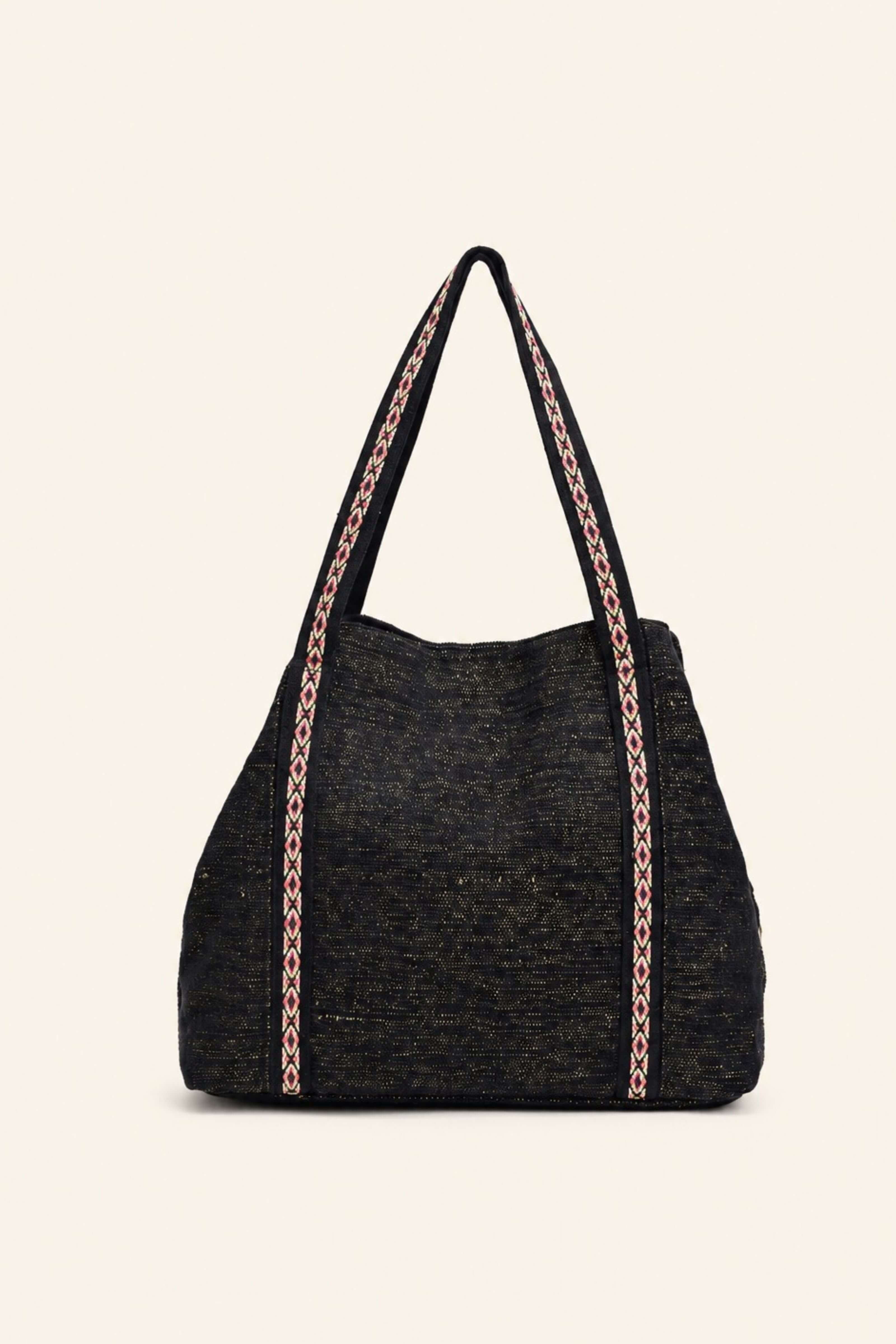 A black woven tote bag with pink and white patterned shoulder straps, shown against a solid off-white background.