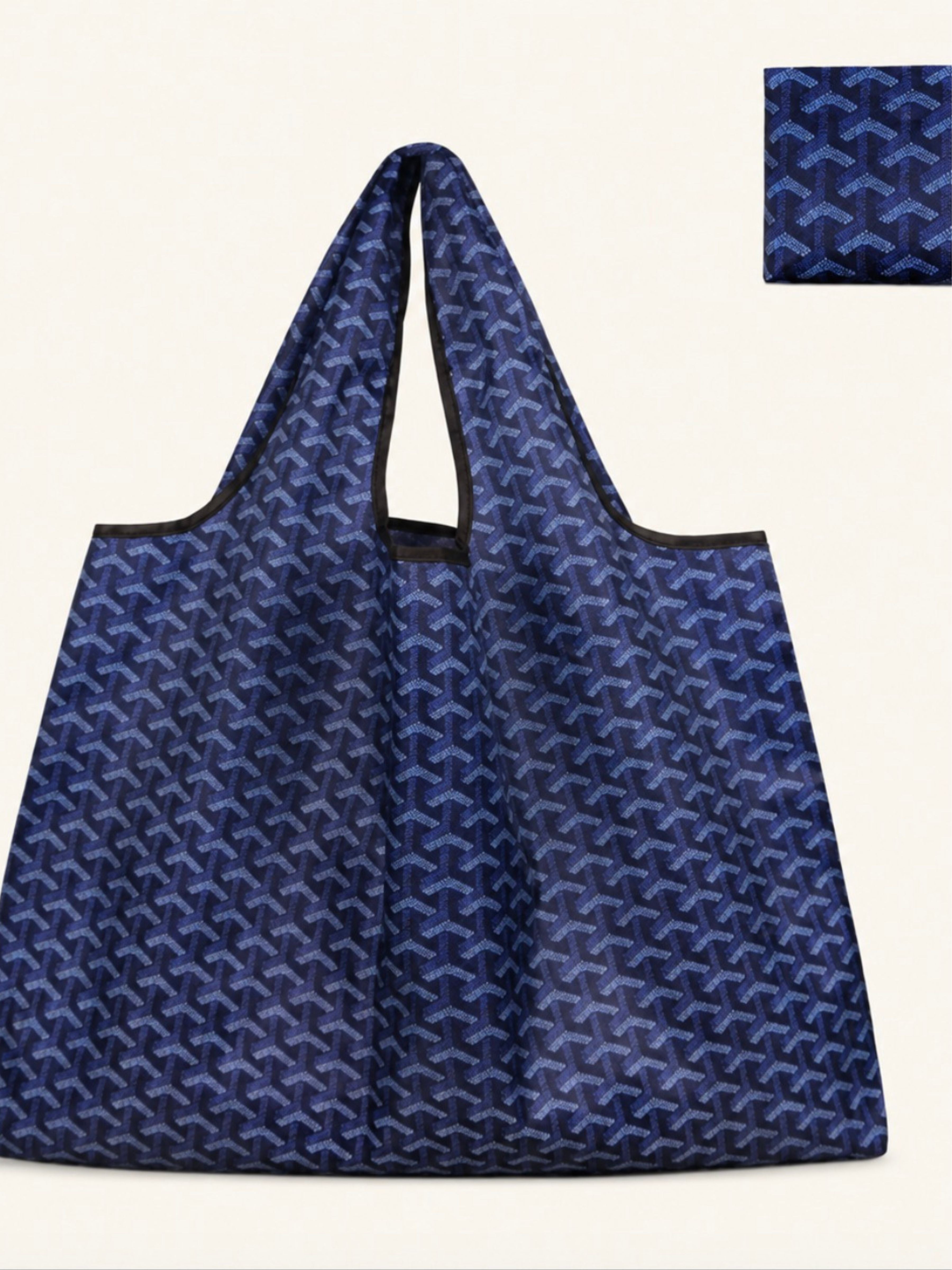 A blue reusable tote bag with a repeating geometric pattern, shown against a light cream background with a small inset detail of the pattern in the top right corner.