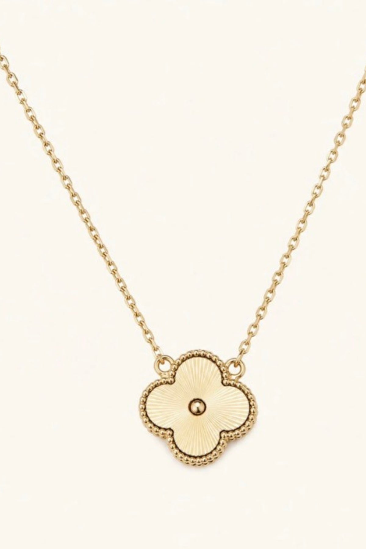 Foxy Gold Quatrefoil Necklace on a cream background